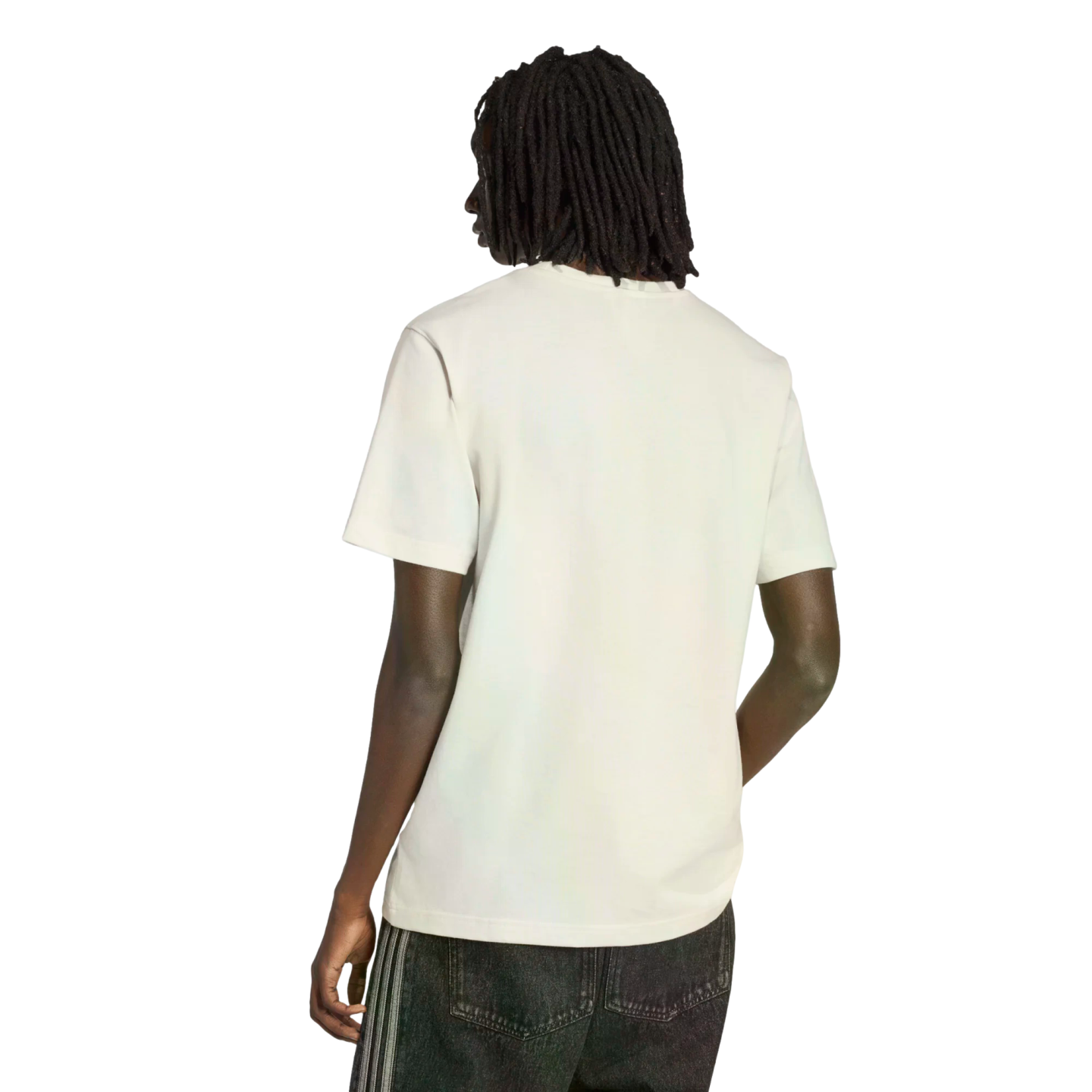 Rear view of a person with long dreadlocks wearing a plain white t-shirt and dark jeans against a black background.