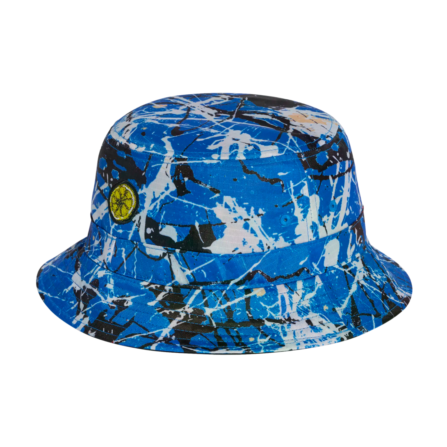 A blue bucket hat with a black and white paint splatter pattern and a small yellow citrus slice patch on the side.