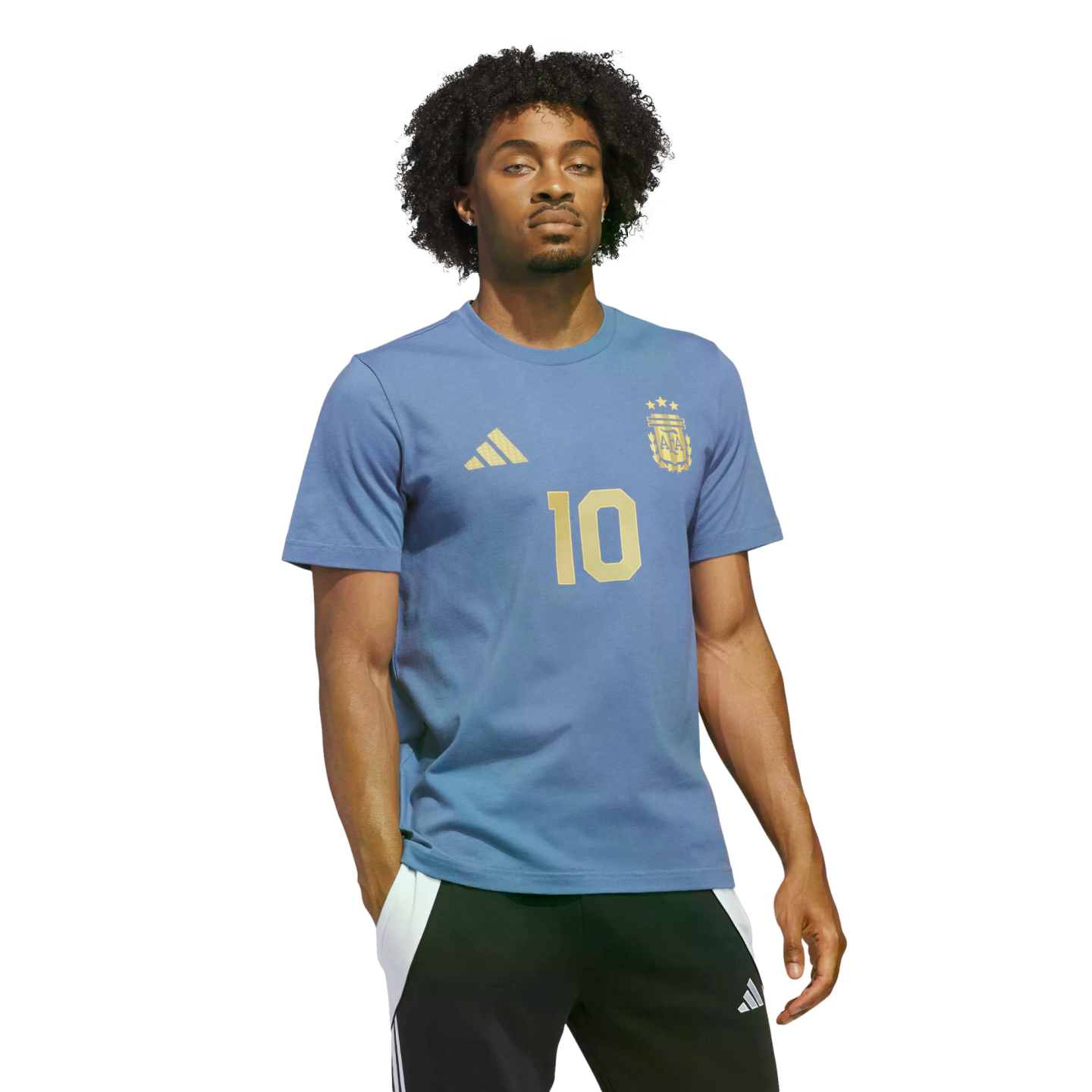 Man with curly hair wearing a light blue Argentina t-shirt with a gold number 10, posing against a solid black background.