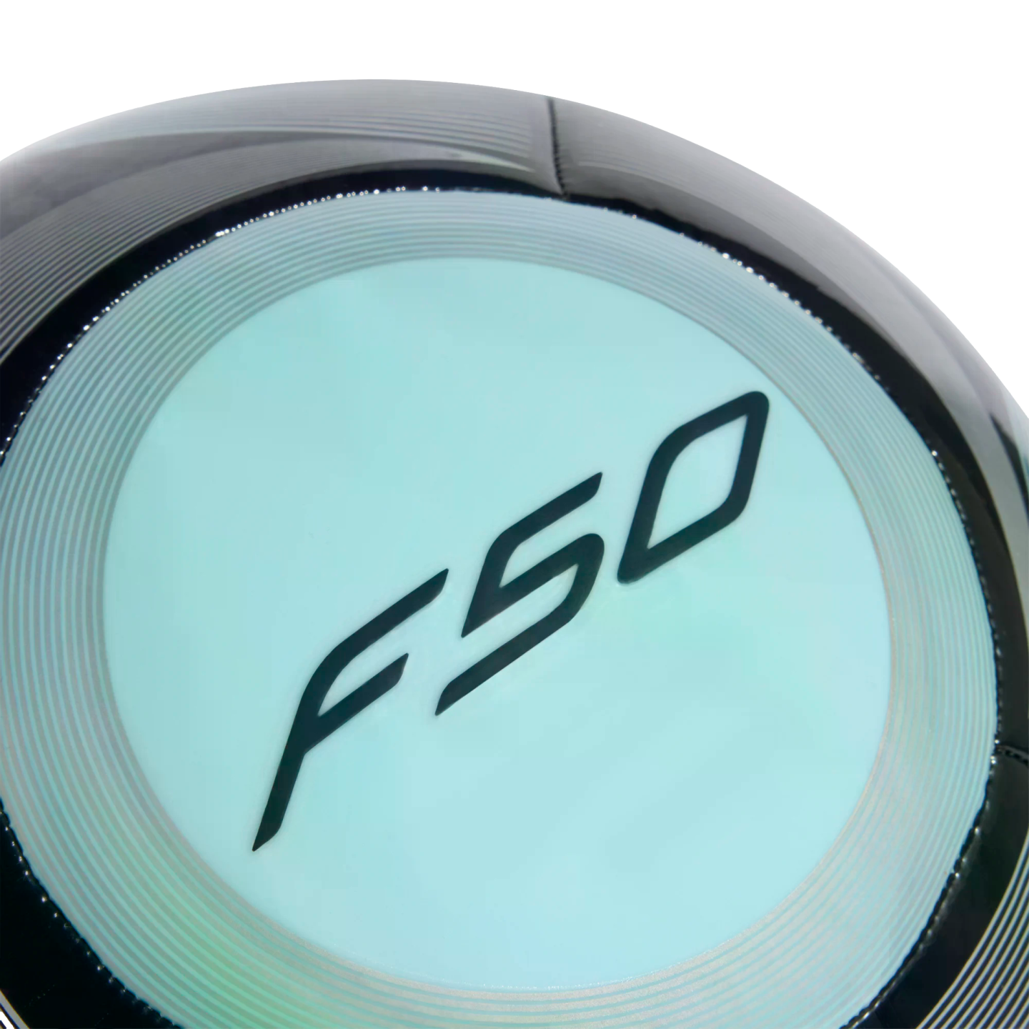 Close-up of a black soccer ball with a light blue circular panel featuring the stylized black "F50" logo.