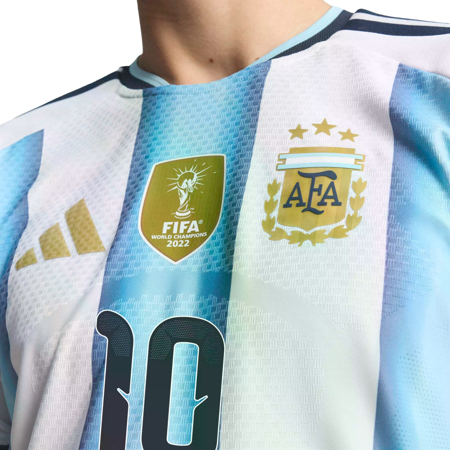 Close-up of an Argentina football jersey with blue and white stripes, featuring the FIFA World Champions 2022 patch, three-star AFA crest, and part of the number 10.