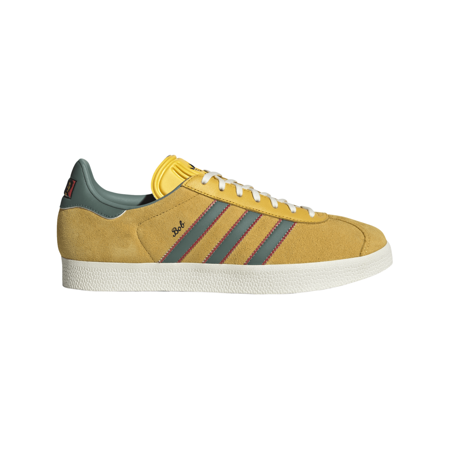 Side view of a yellow suede sneaker with grey stripes, red zig-zag stitching, white soles, and "Bob" written in script on the side.