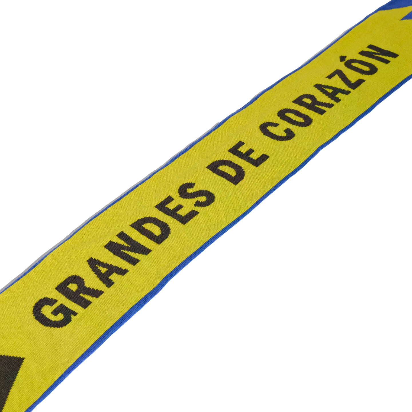 Yellow fabric banner with blue borders and black text reading "GRANDES DE CORAZÓN" against a black background.