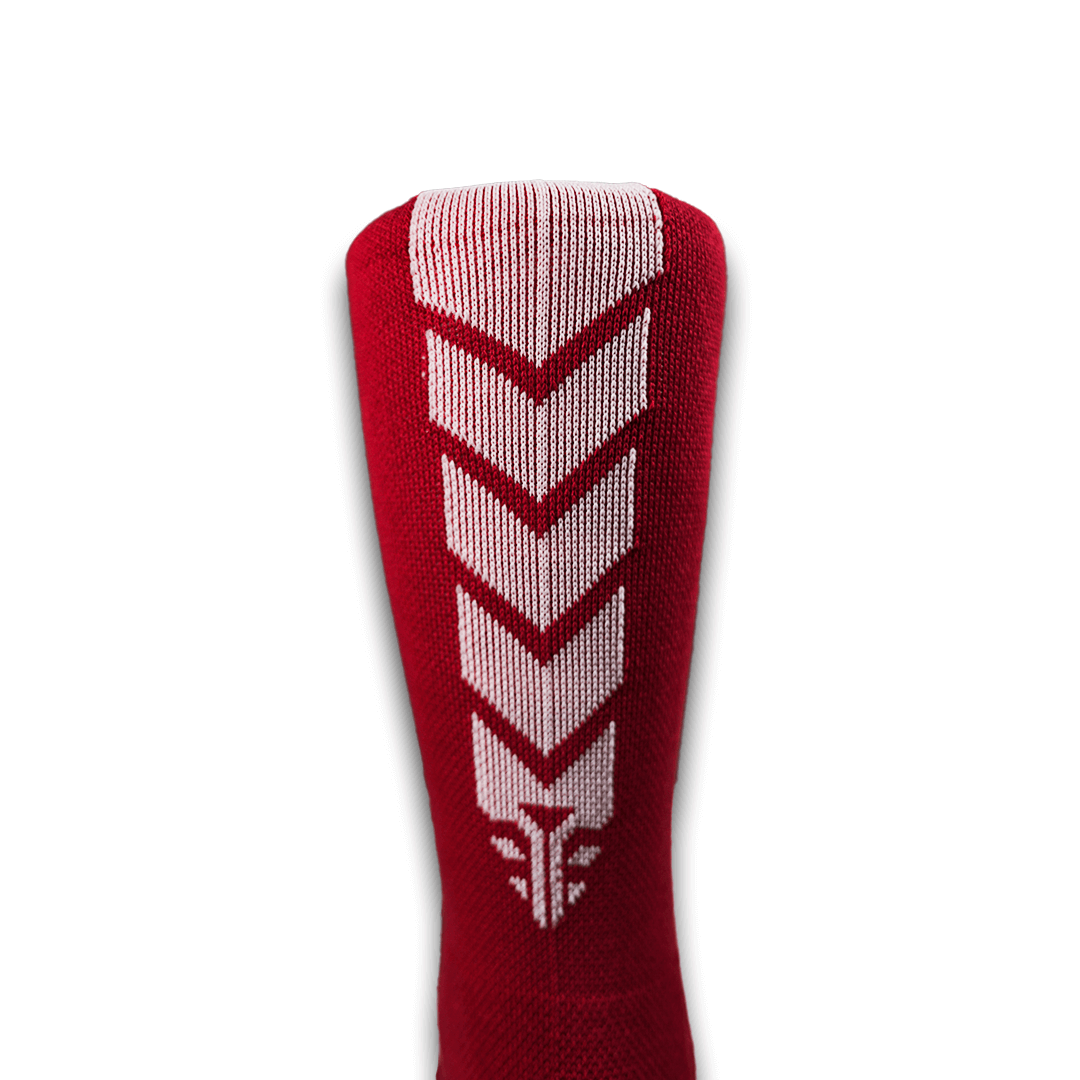A close-up view of the For The Footballer XLR8R Pro No Slip Socks in red, showcasing a white chevron and geometric pattern on the back of the knit sock.