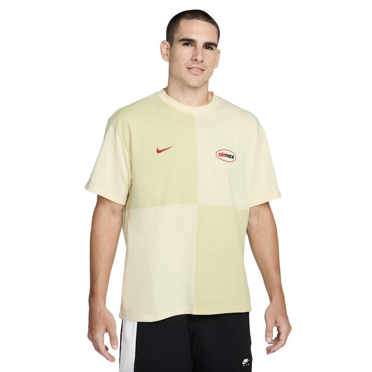 A man modeling a pale yellow and green color-block Nike Air Max t-shirt.