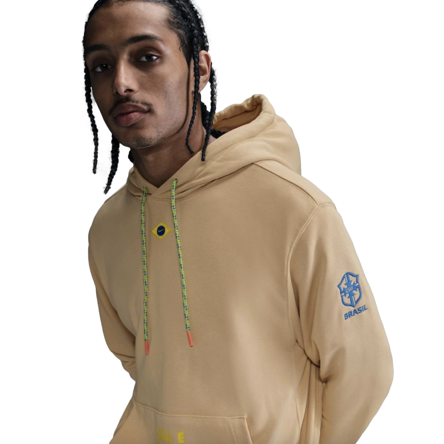 Man with braids wearing a tan Brasil hoodie featuring a CBF logo on the sleeve and colorful drawstrings.