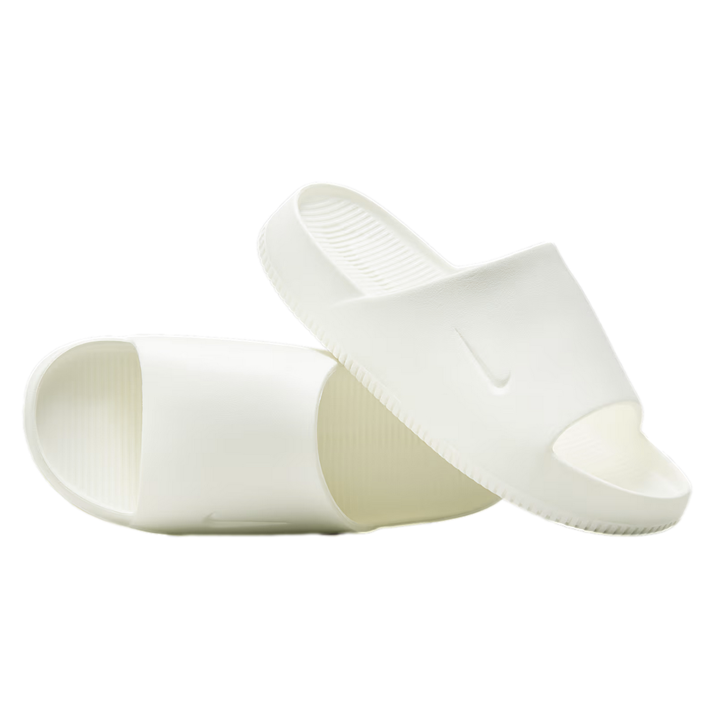 A pair of all-white Nike slides on a white background. One slide rests diagonally on top of the other, showcasing the subtle swoosh logo and contoured footbed.