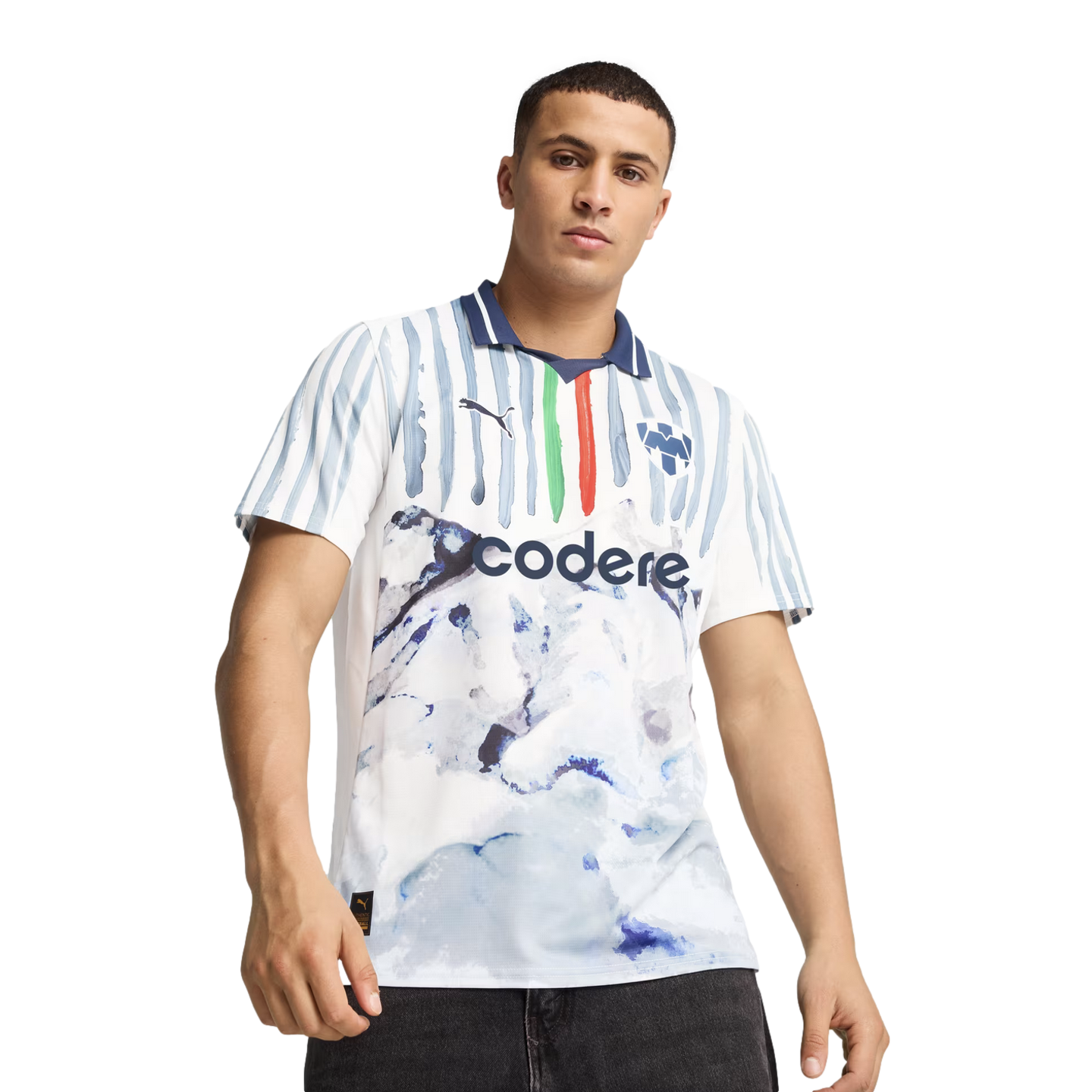 A man models a white soccer jersey with blue stripes and a marbled pattern, featuring the "codere" sponsor logo and a blue collar, set against a plain white background.