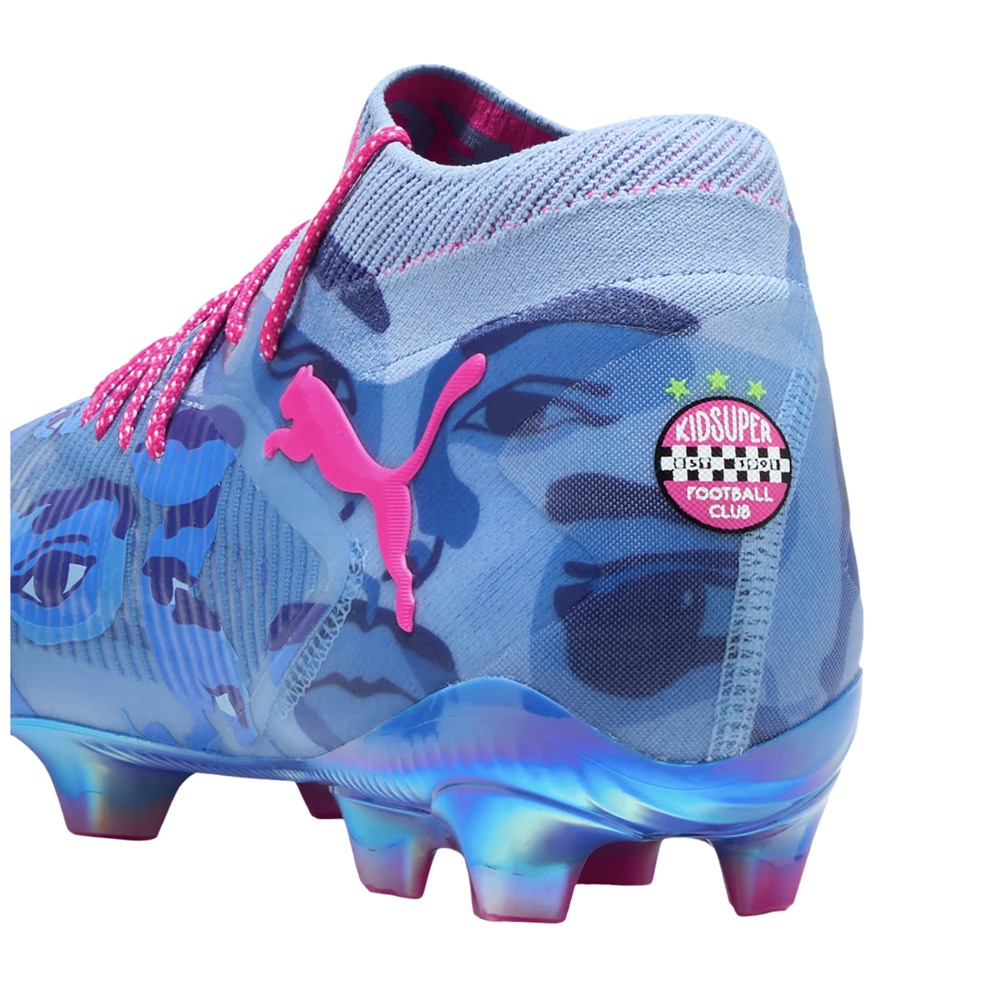 A Puma x KidSuper soccer cleat in light blue with dark blue face graphics, pink accents, and an iridescent sole. A KidSuper Football Club badge is displayed on the heel.