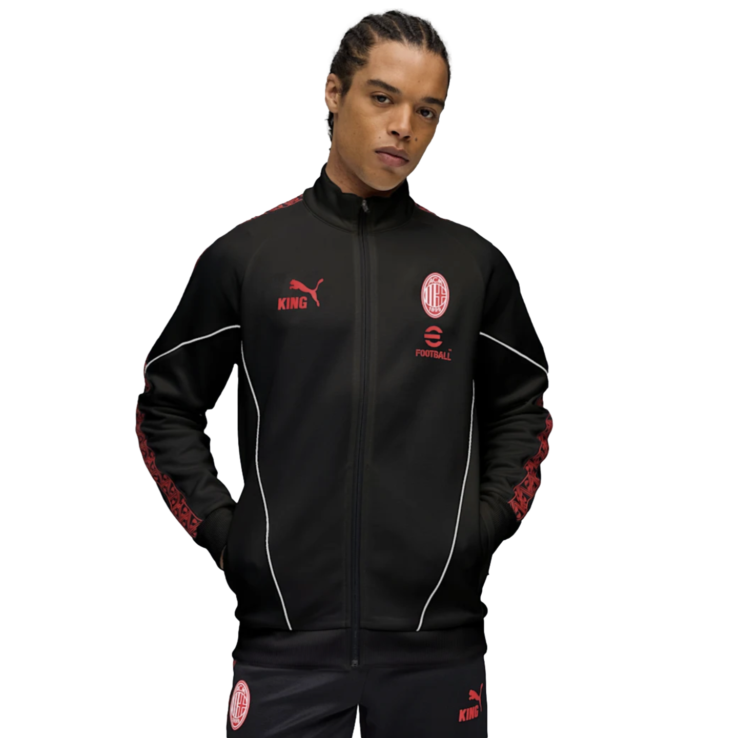 A male model wearing a black AC Milan x Puma 'KING' tracksuit with red accents and white piping, set against a plain white background.