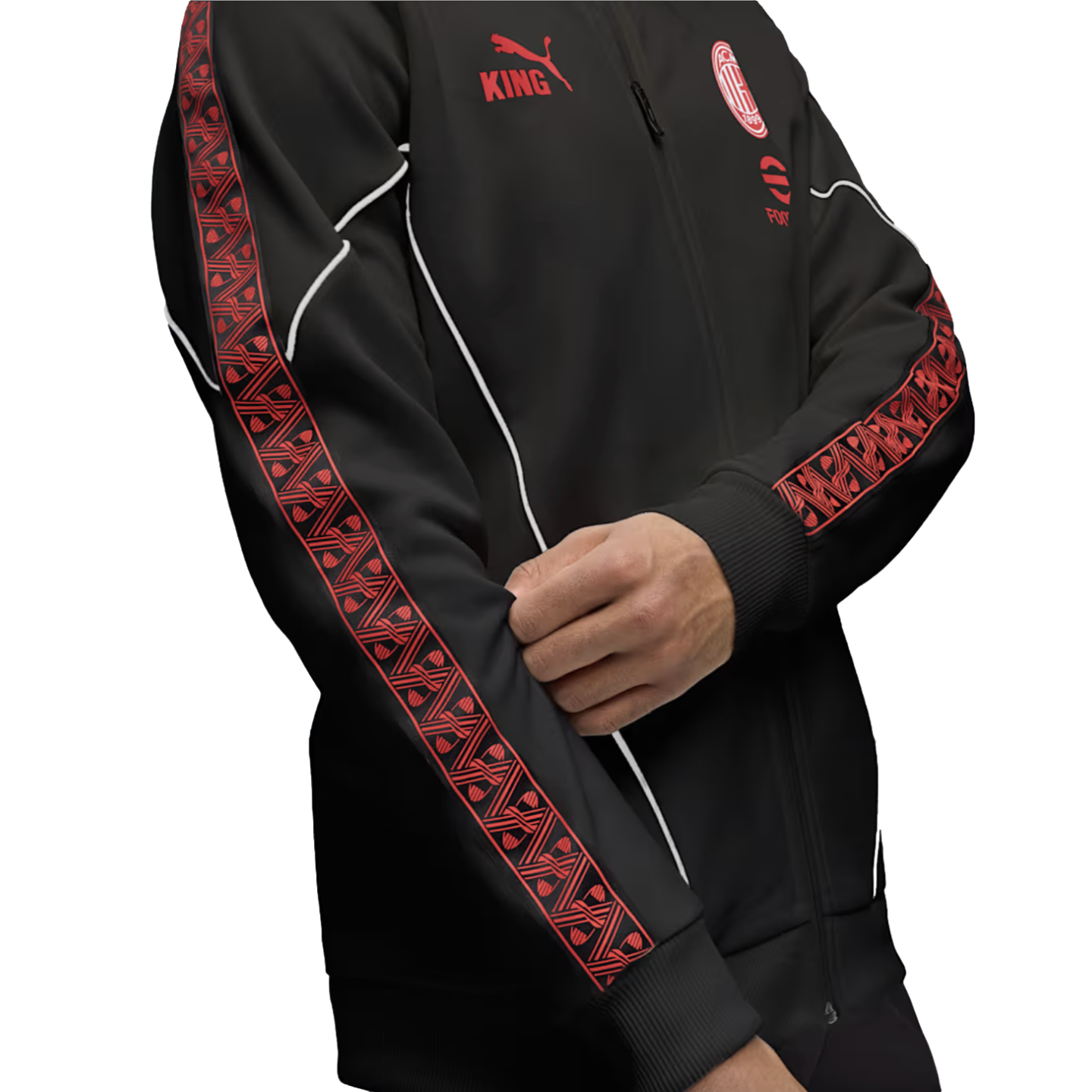 A person wearing a black Puma AC Milan track jacket with red patterned sleeve stripes, white piping, and red team logos against a white background.