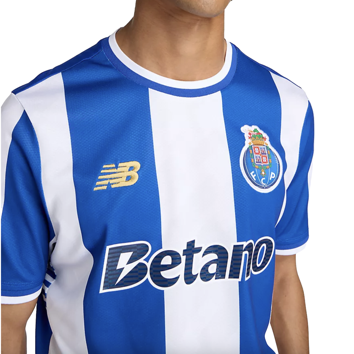 A person wears an FC Porto home jersey featuring blue and white vertical stripes, the club crest, a gold New Balance logo, and the Betano sponsor name.