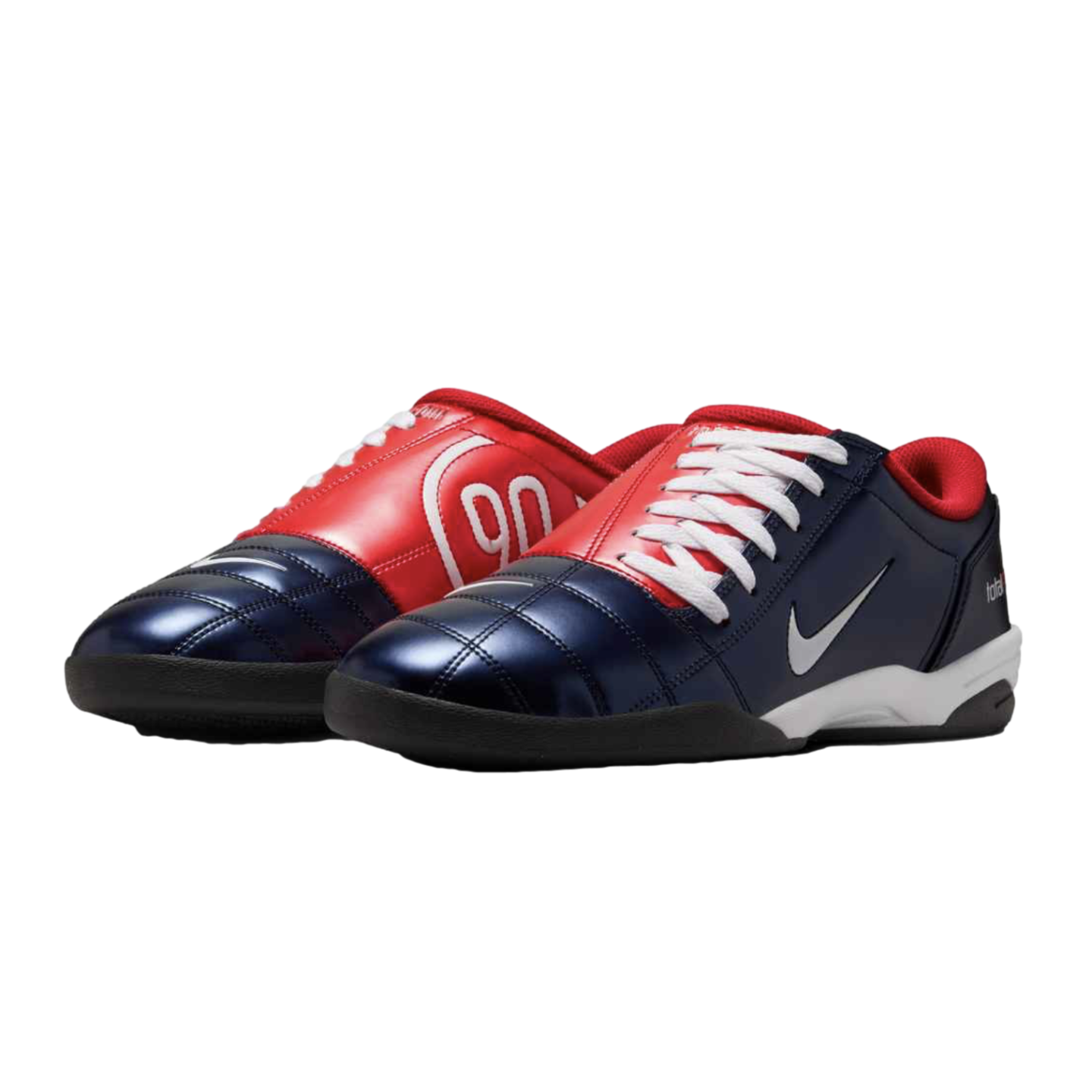 Navy blue and red Nike Total 90 indoor soccer shoes with white laces and a swoosh on a black background.