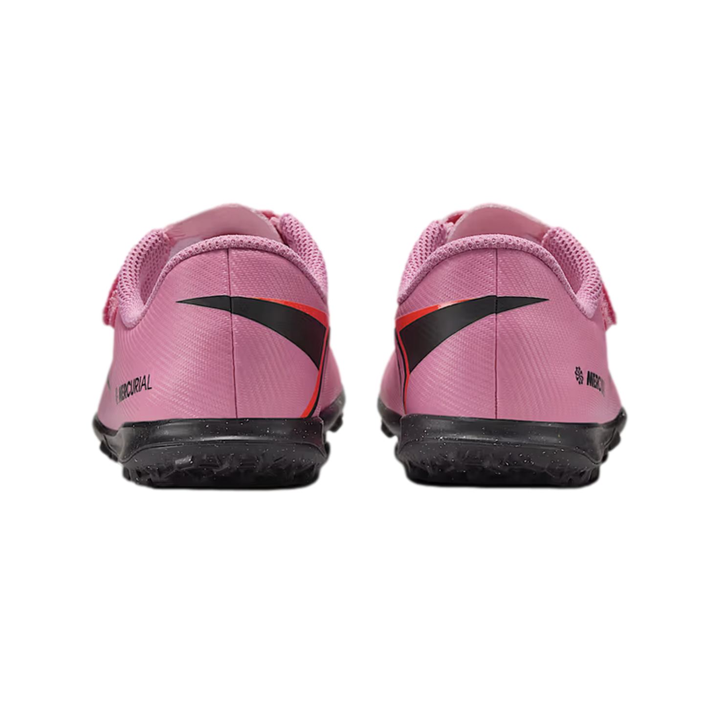 Rear view of pink Nike Mercurial turf soccer shoes with black soles, isolated on a black background.