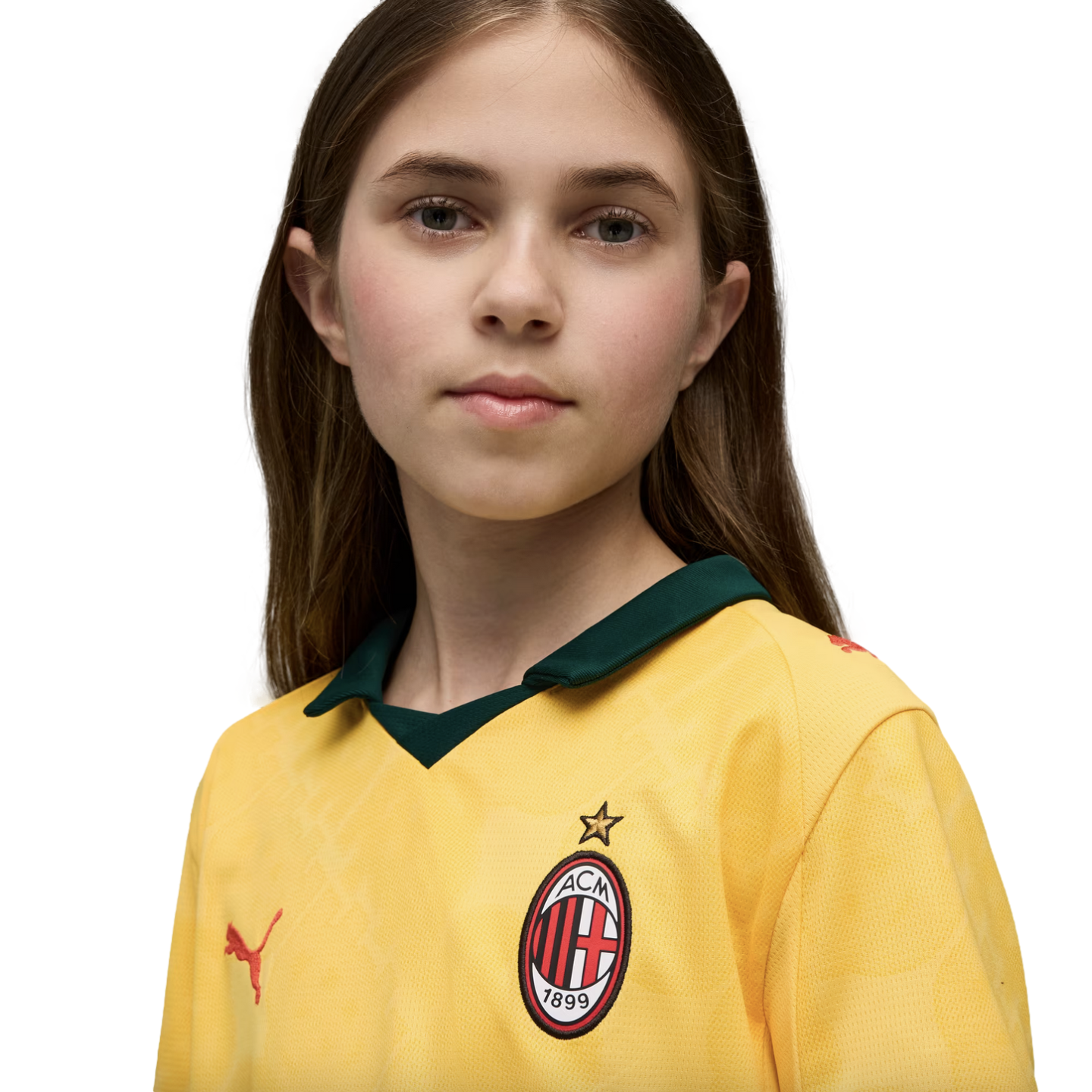 A portrait of a young person with long brown hair wearing a yellow AC Milan soccer jersey against a solid black background.