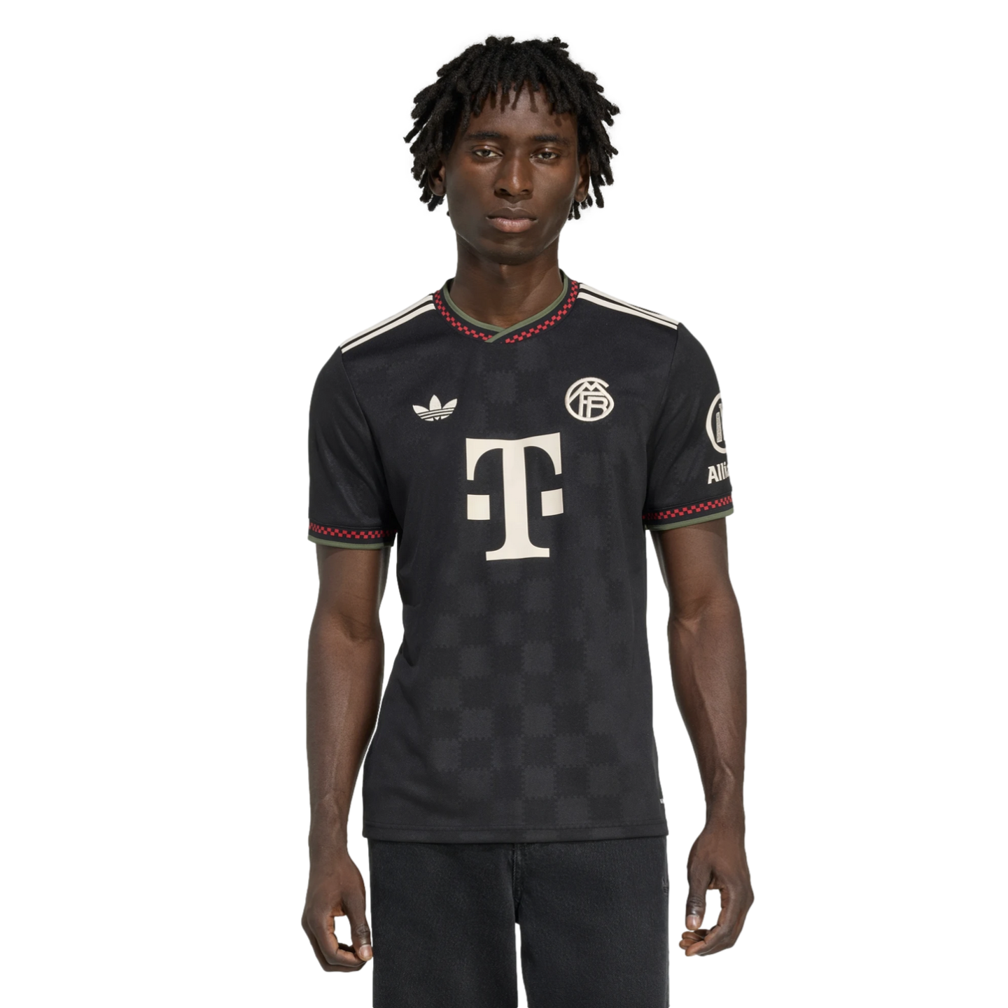 Man wearing a black Bayern Munich soccer jersey with white logos and red and green trim on the collar and sleeves, against a black background.