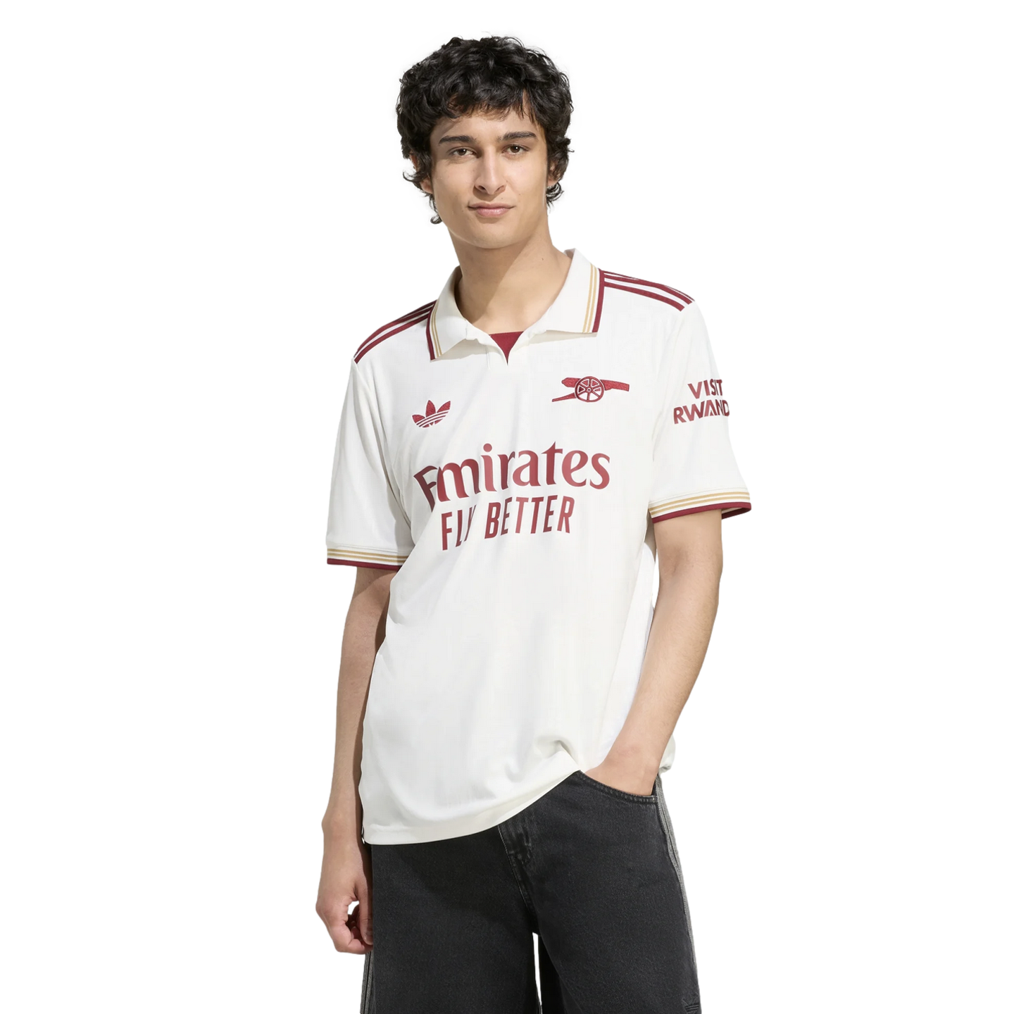 A man wearing a white Arsenal FC jersey with maroon and gold accents, standing against a black background.