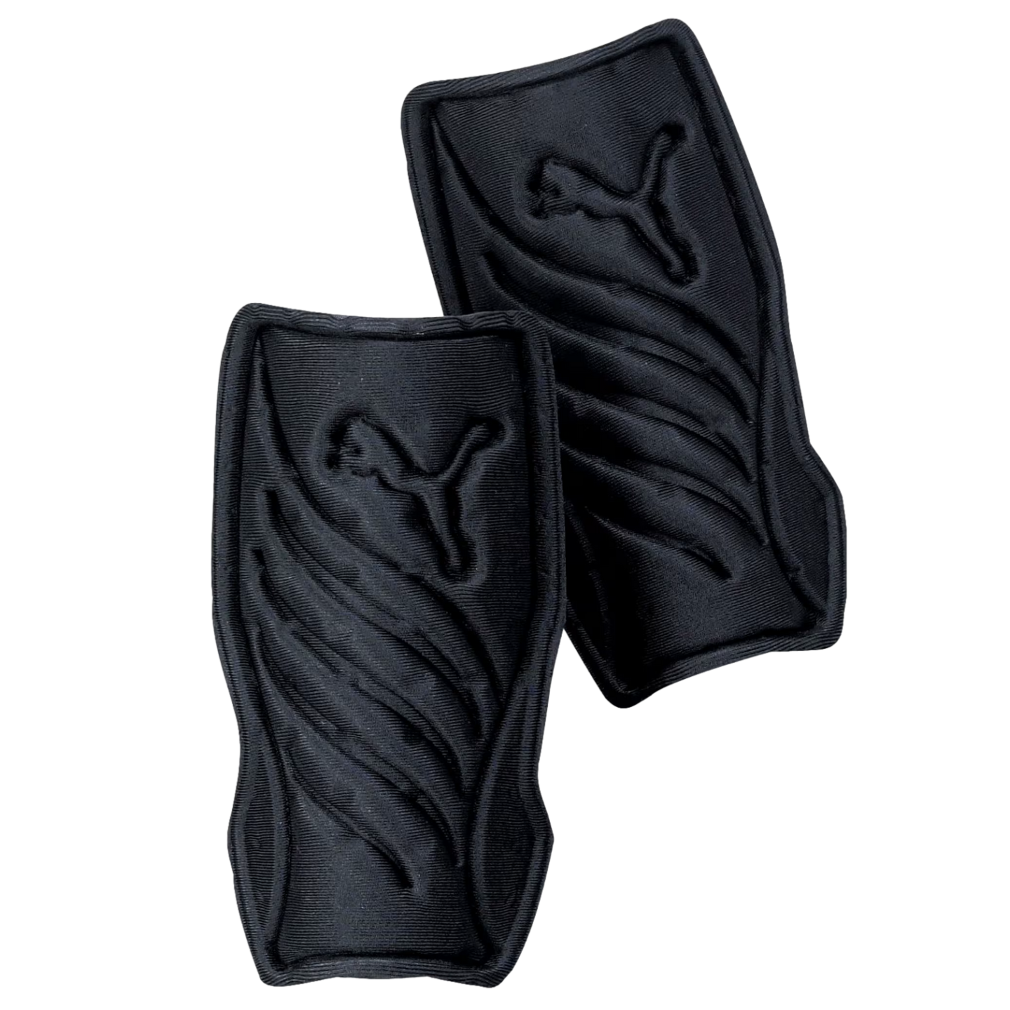 A pair of black Puma soccer shin guards with embossed leaping cat logos and curved ridges, set against a black background.