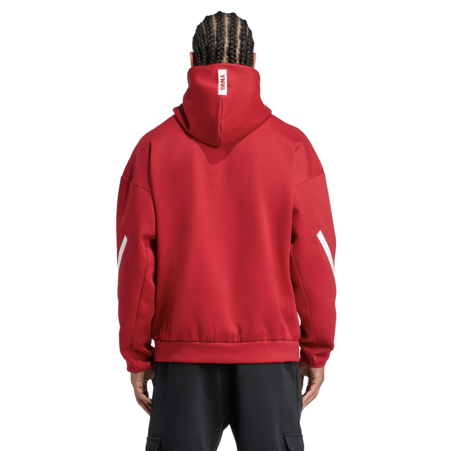 Back view of a person with braids wearing a red hoodie with white 'YNWA' branding and sleeve accents, paired with black pants against a black background.