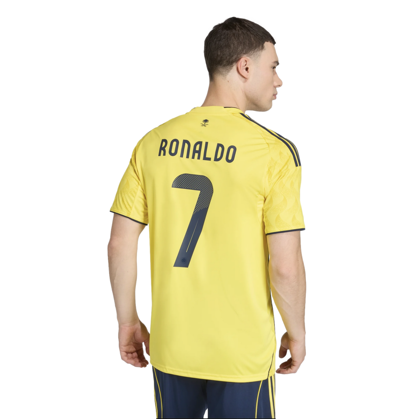 Back view of a man wearing a yellow soccer jersey with "RONALDO" and the number "7" printed in navy blue on the back, set against a solid black background.