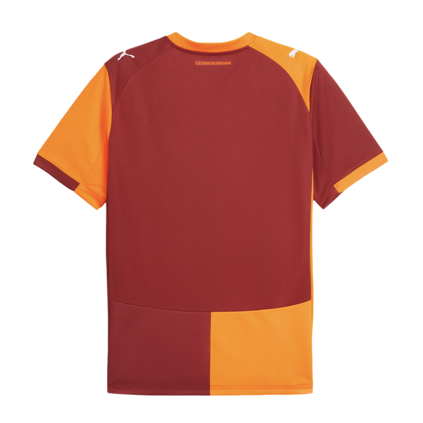 The back of a maroon and orange Puma football jersey with split-color panels and shoulder logos. A small Turkish phrase is printed below the orange collar.