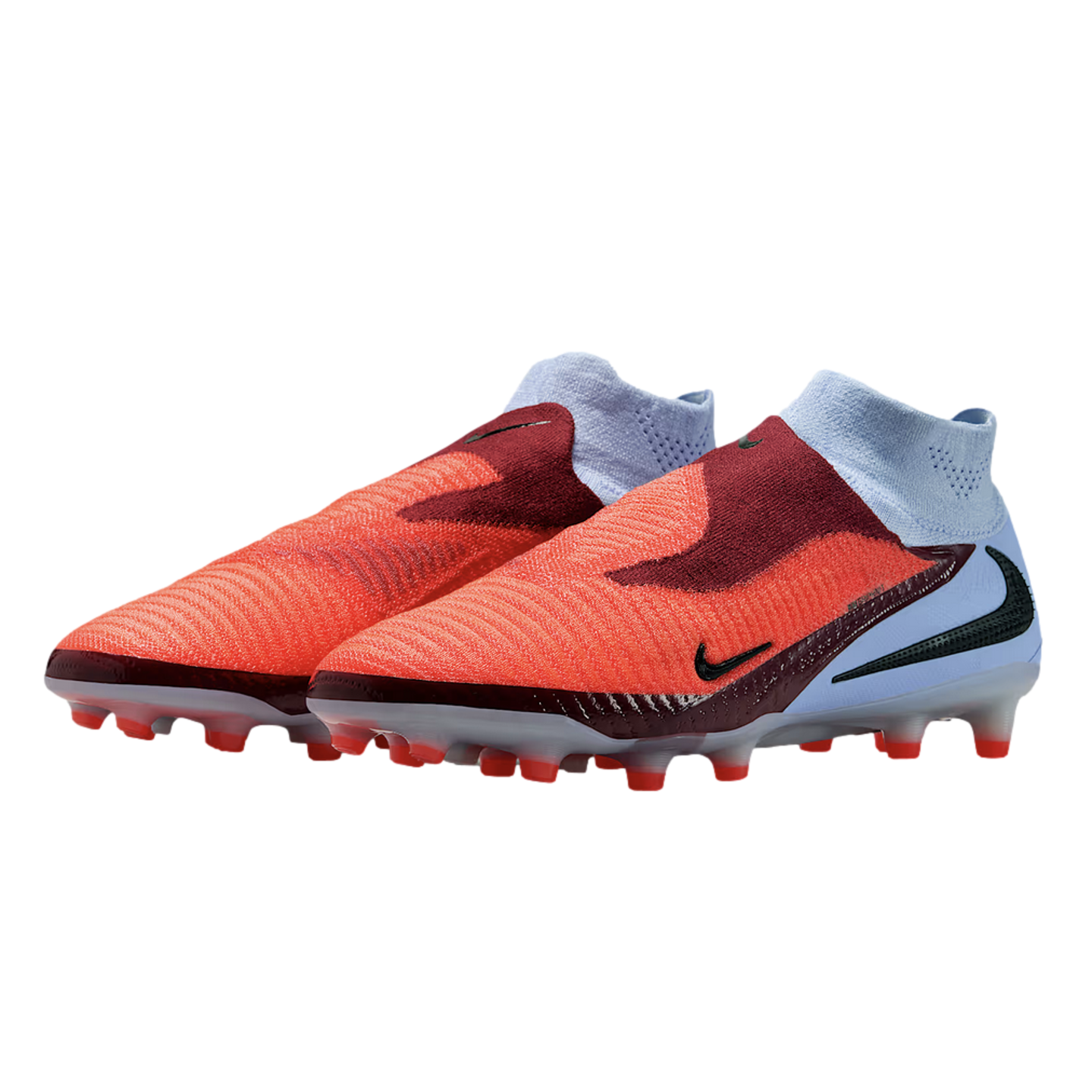 Pair of laceless Nike soccer cleats in bright orange, dark red, and light blue with red studs, set against a black background.