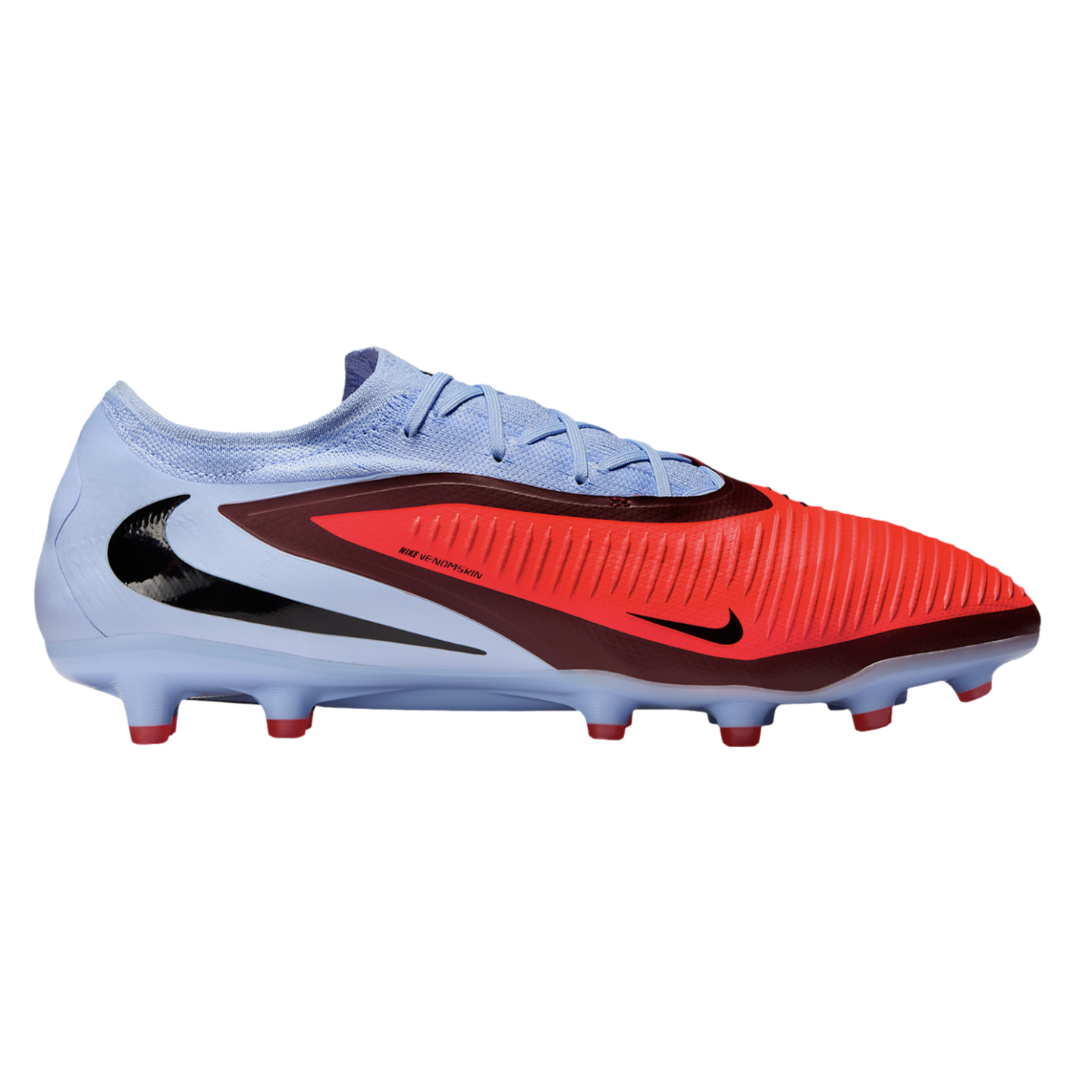 A Nike Venomskin soccer cleat featuring a light blue upper with bright red and burgundy accents, a large black swoosh on the heel, and red-tipped studs.