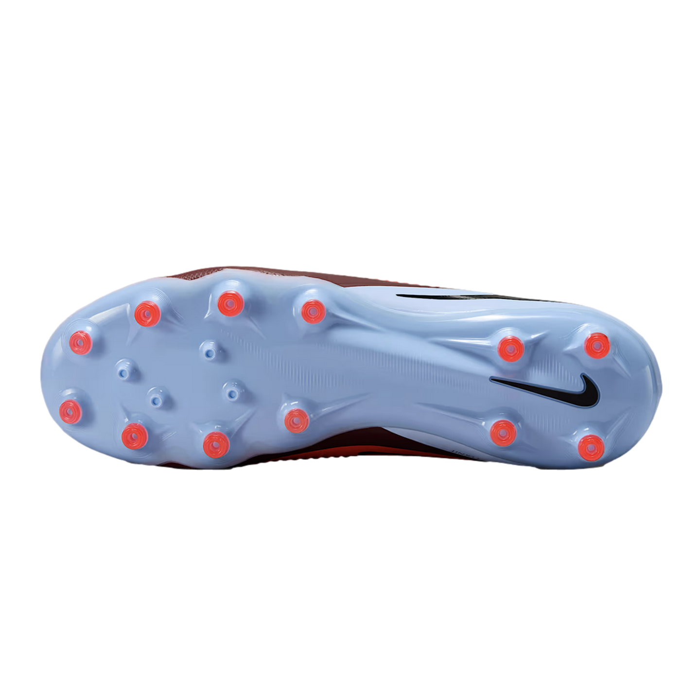 The sole of a light blue Nike soccer cleat features several red conical studs and a black Nike swoosh on the heel, all set against a black background.