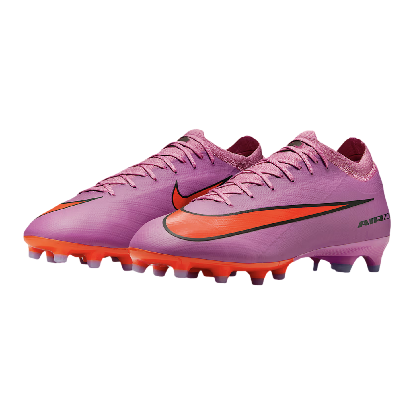 A pair of pink Nike Air Zoom soccer cleats with bright orange accents on the sole and logo, isolated on a black background.