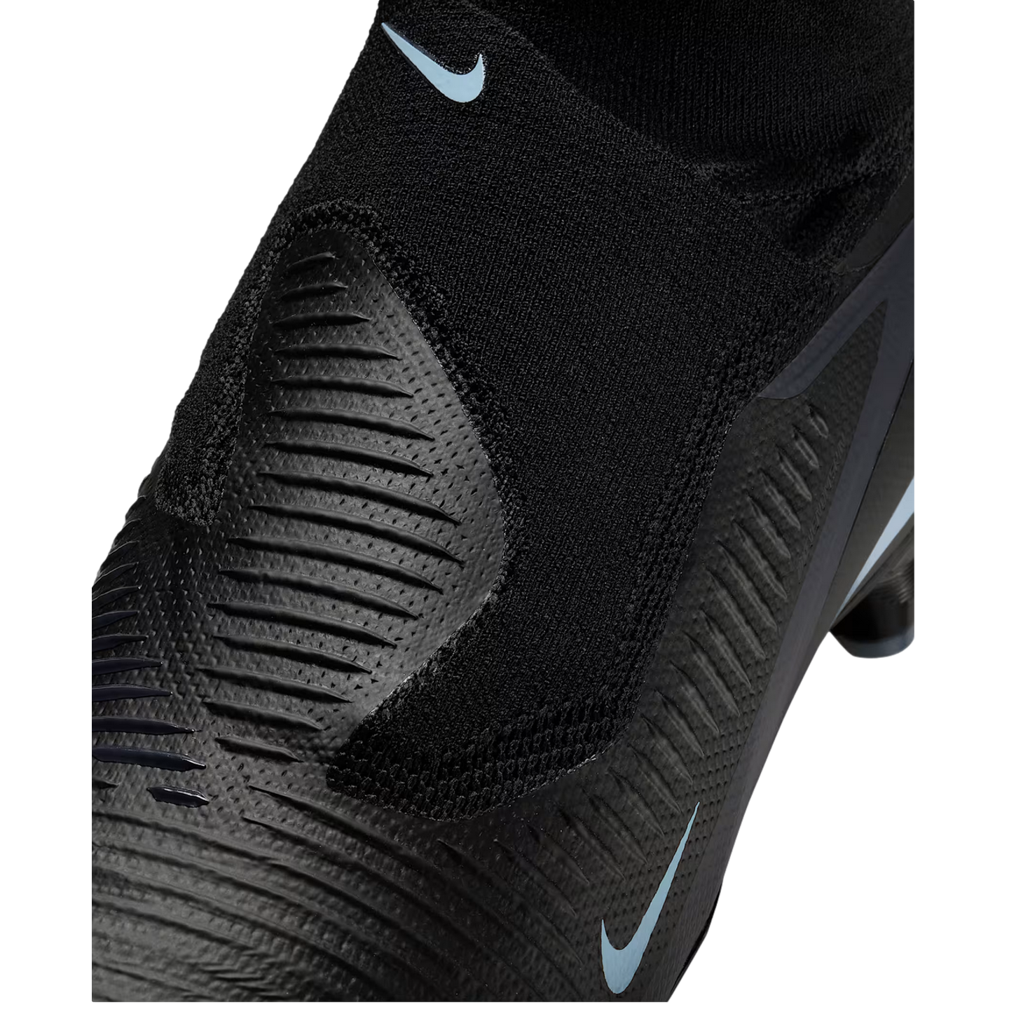 Close-up of a black Nike soccer cleat featuring a textured upper and light blue swoosh logos.
