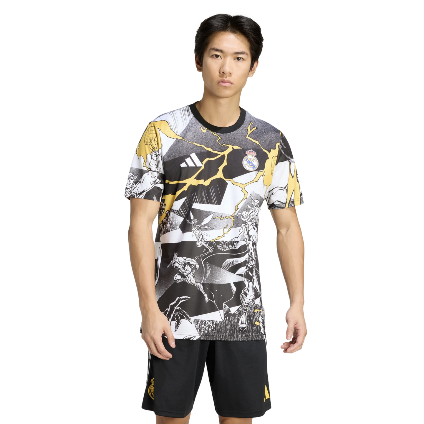 Man in a black, white, and yellow Real Madrid x Marvel graphic tee and black shorts against a solid black background.