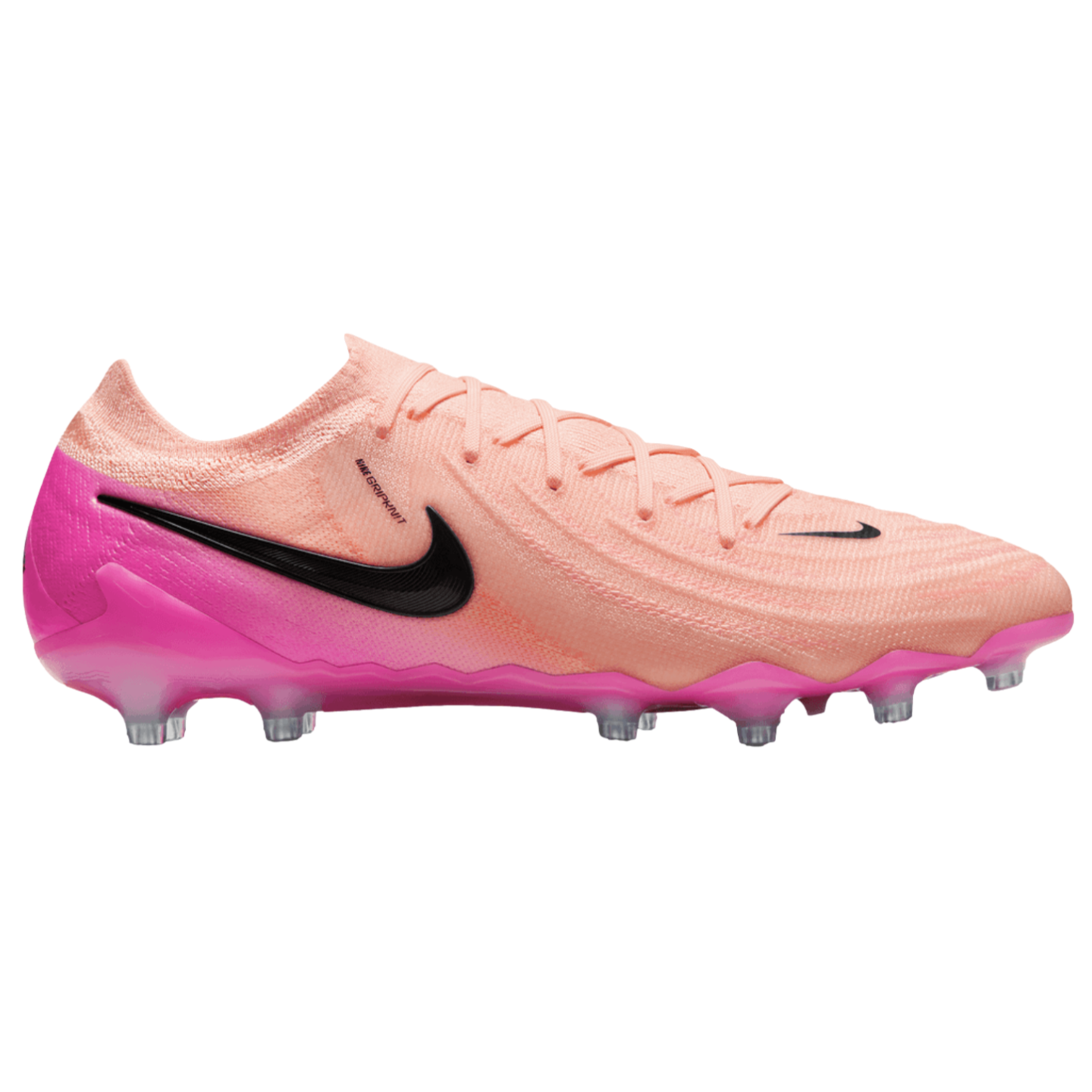Side profile of a peach and bright pink Nike soccer cleat with black swooshes and transparent studs, shown against a solid black background.