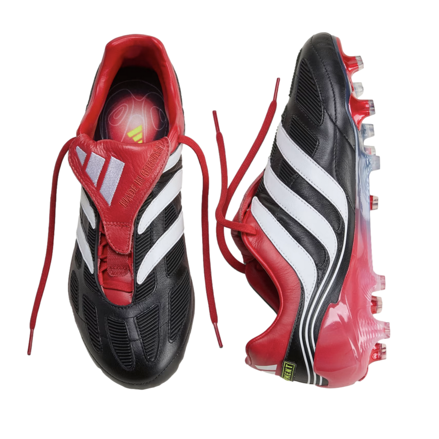 Top and side views of black, red, and white Adidas Predator soccer cleats against a black background.