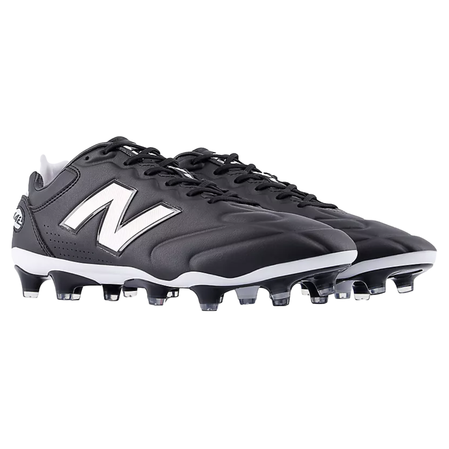 A pair of black and white New Balance soccer cleats featuring the iconic white "N" logo on the side and a studded outsole, set against a black background.