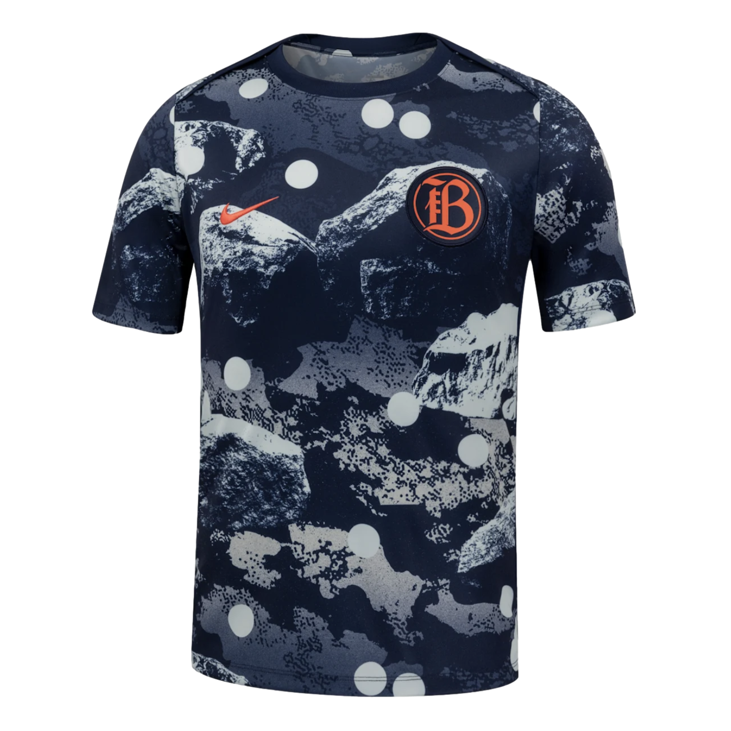 A Nike short-sleeved shirt featuring a navy and grey abstract mountain print with large white polka dots, an orange swoosh, and a circular "FB" crest on the chest.