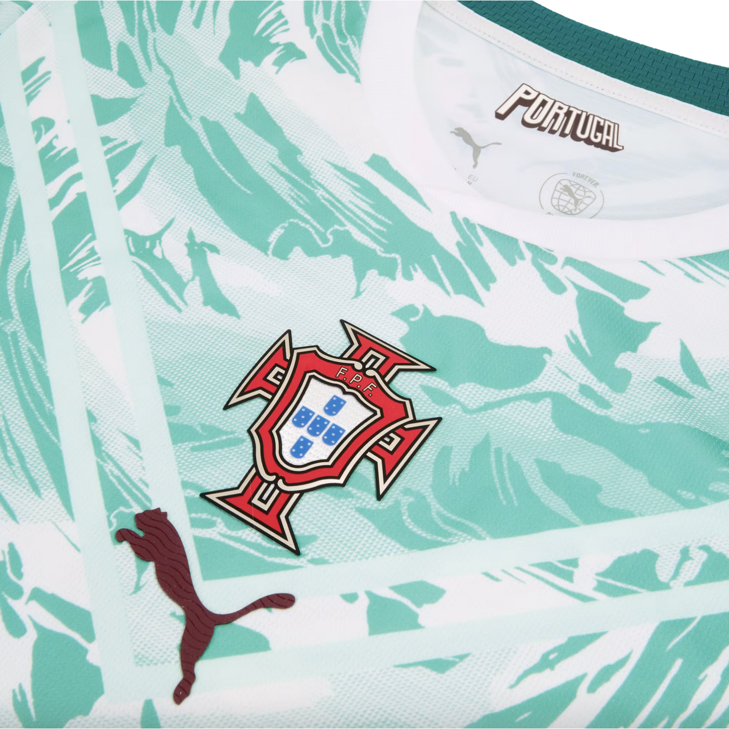 A close-up of the chest area of a Portugal national football team jersey, featuring a white and mint green abstract marbled pattern. The team crest is centered, with a dark maroon textured Puma logo on the lower left and stylized "PORTUGAL" text inside th