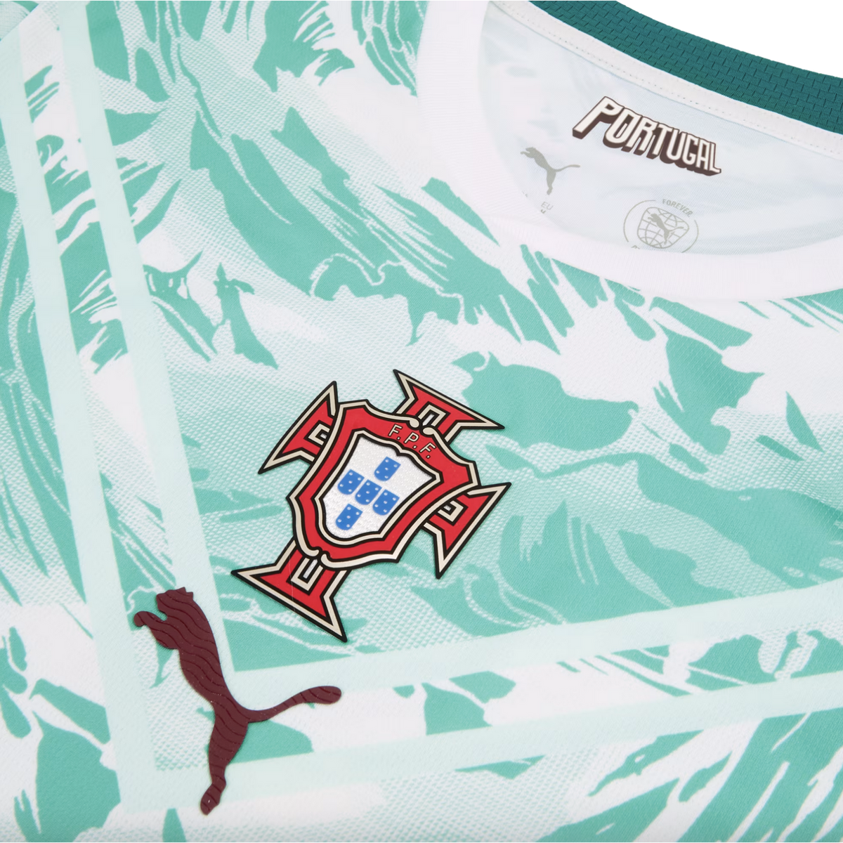 A close-up of the chest area of a Portugal national football team jersey, featuring a white and mint green abstract marbled pattern. The team crest is centered, with a dark maroon textured Puma logo on the lower left and stylized "PORTUGAL" text inside th