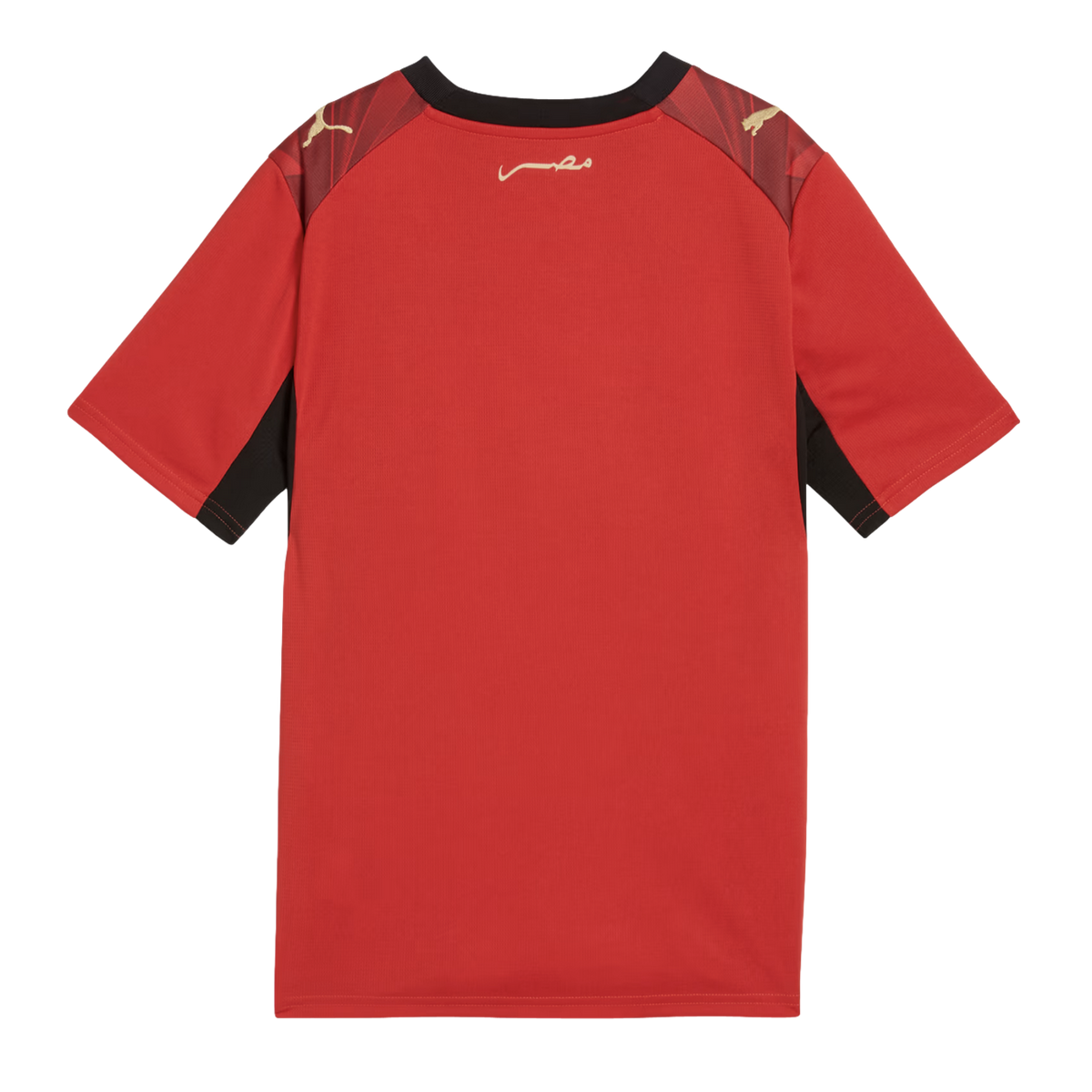 A back view of a red short-sleeved Puma jersey with black trim around the collar and underarms. It features gold Puma logos on the shoulders and gold Arabic calligraphy on the upper back against a black background.