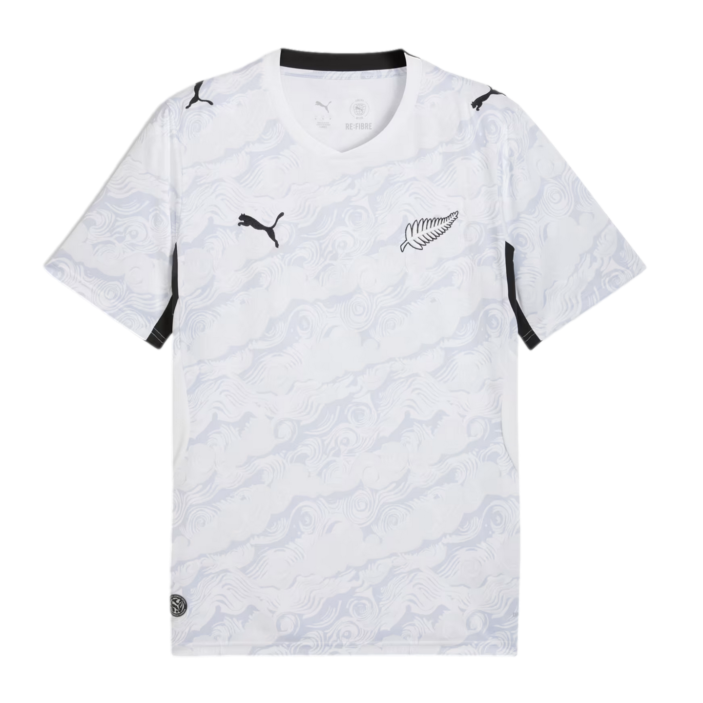 A white Puma short-sleeve soccer jersey featuring an all-over light grey abstract swirling pattern. It displays a black Puma logo on the right chest, a silver fern emblem on the left, and black accents on the collar and sleeve panels.