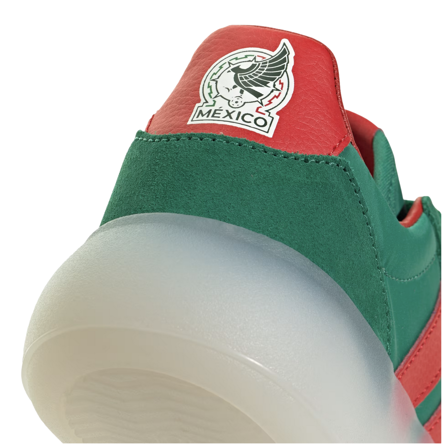 A close-up of the heel of a green and red sneaker featuring a thick translucent sole and a patch of the Mexico national soccer team logo.