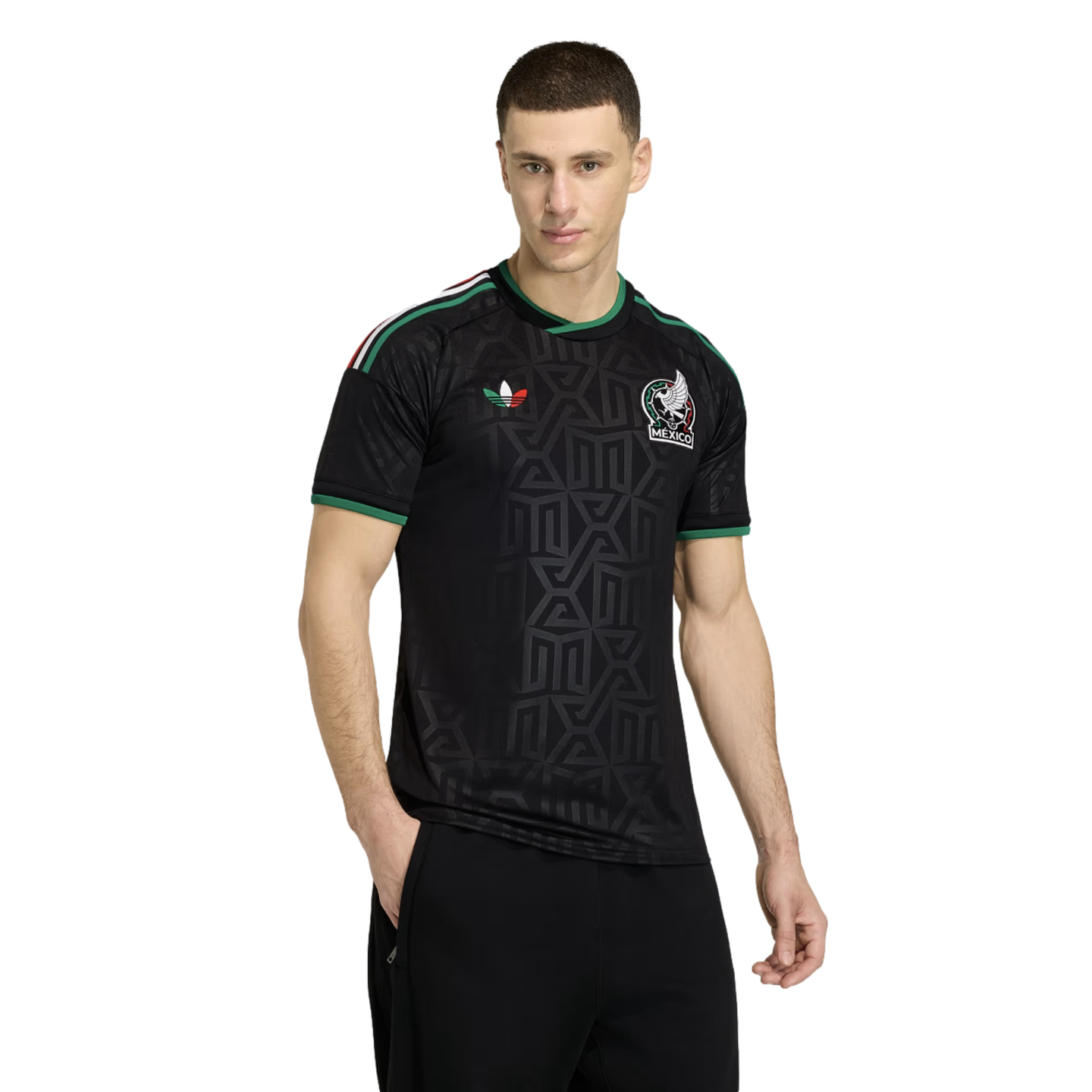 A man models a black Adidas Mexico national team soccer jersey with green trim and geometric patterns, standing against a plain white background.