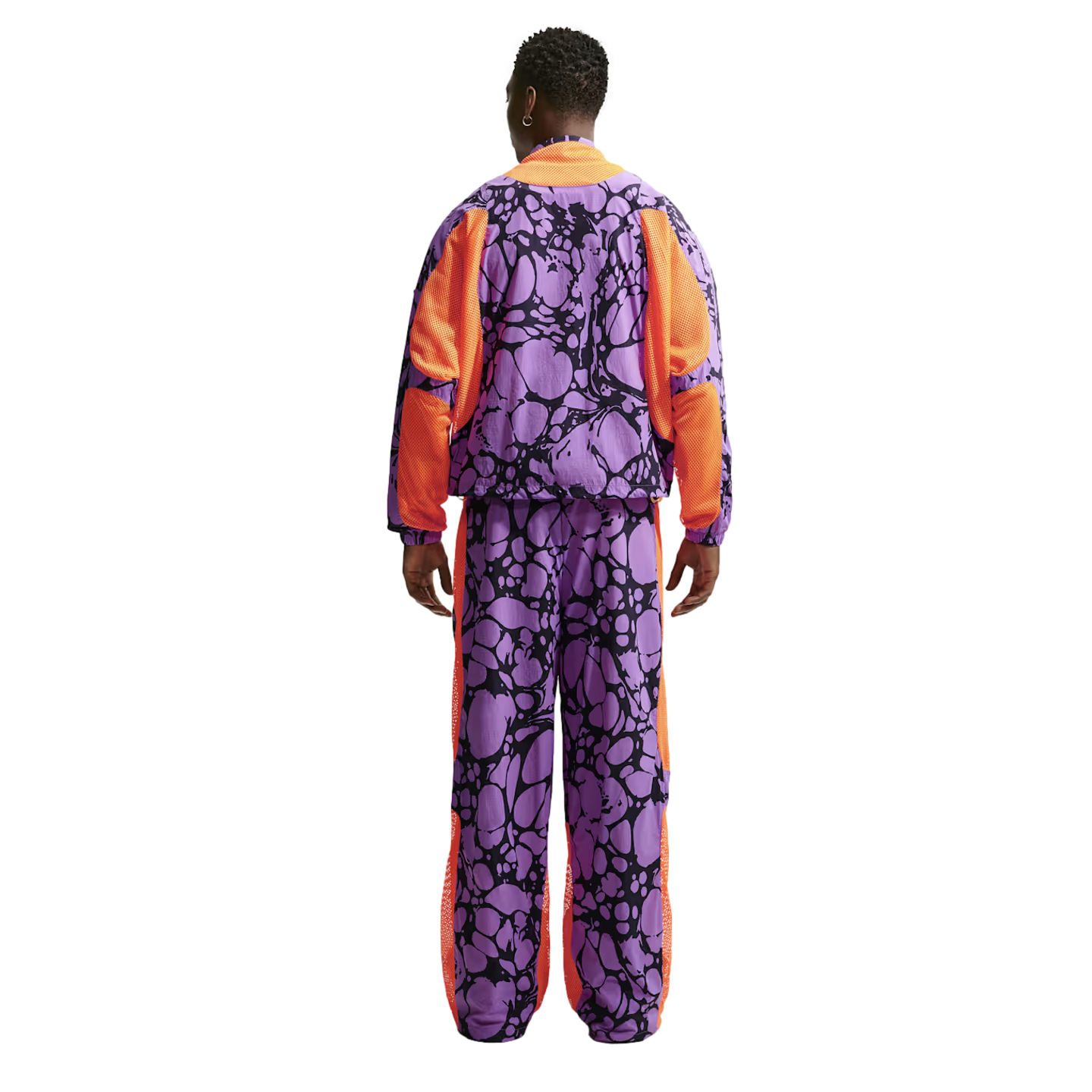 Rear view of a person wearing a purple and orange tracksuit with a black organic pattern and orange mesh accents.