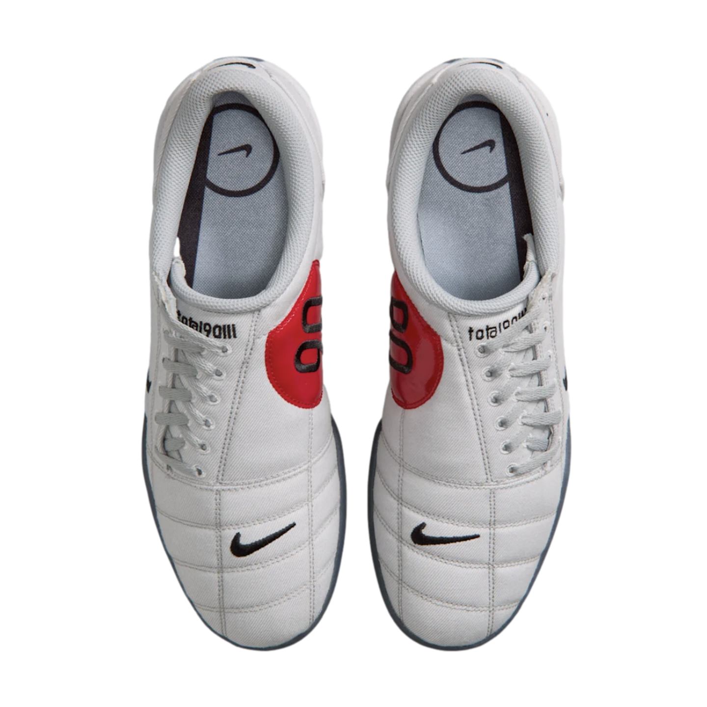 Top-down view of a pair of white Nike Total 90 III soccer shoes with prominent red circular accents featuring the number 90 on the sides.