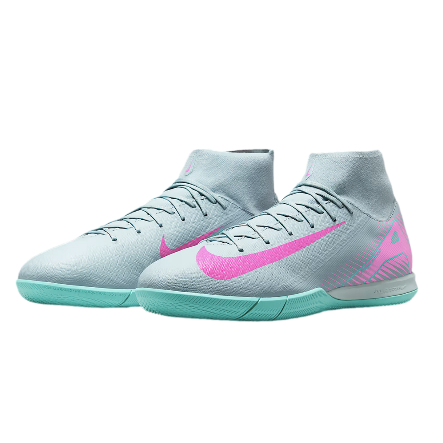 Light grey Nike indoor soccer shoes with turquoise soles and bright pink swooshes. Features a high-top sock collar and textured upper.