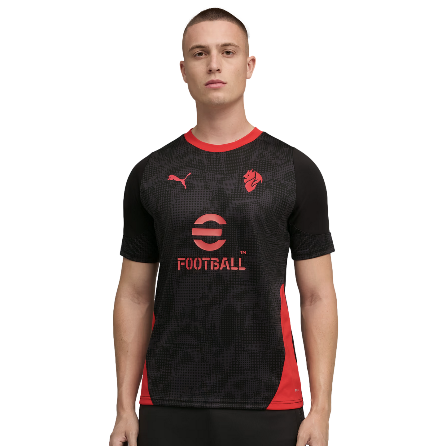A man modeling a black Puma soccer jersey with red accents and the eFootball logo on a black background.