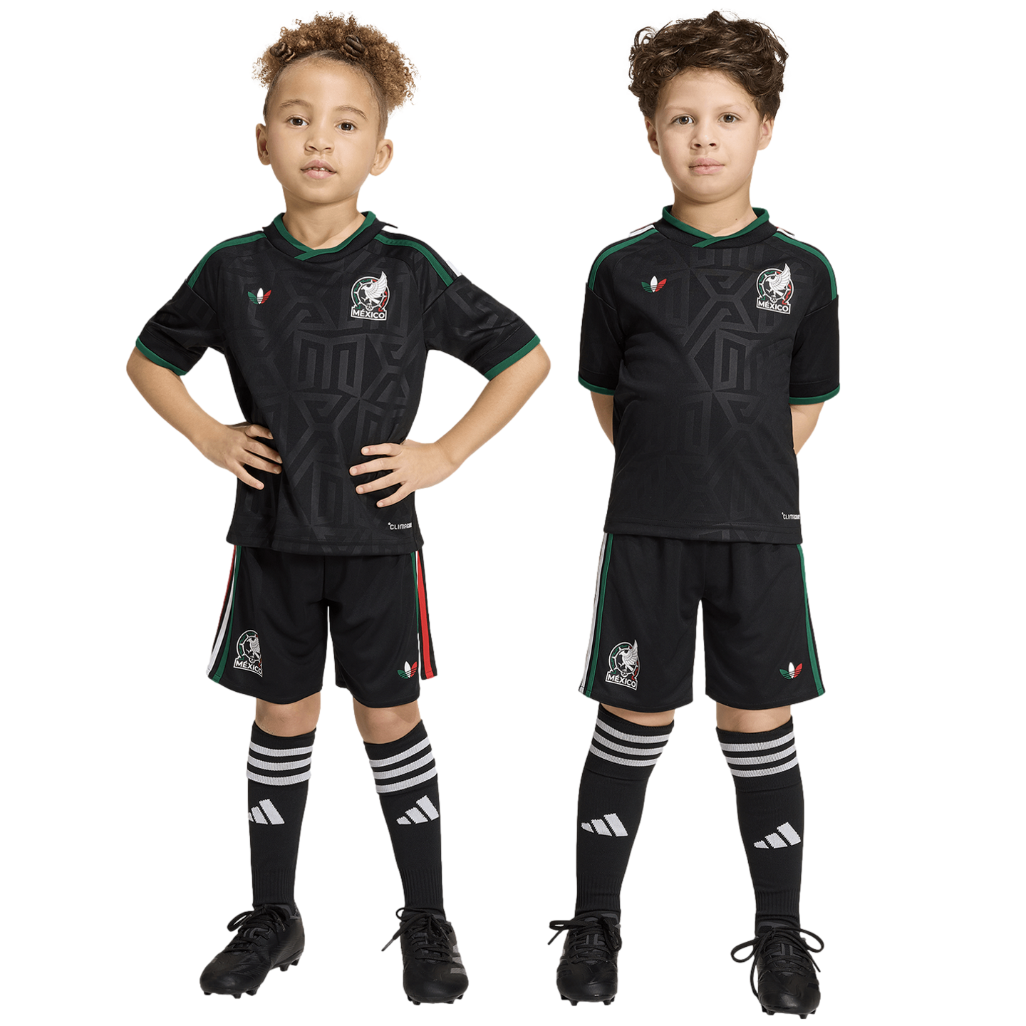 Two children pose side-by-side in matching black Mexico national soccer team kits against a white background.