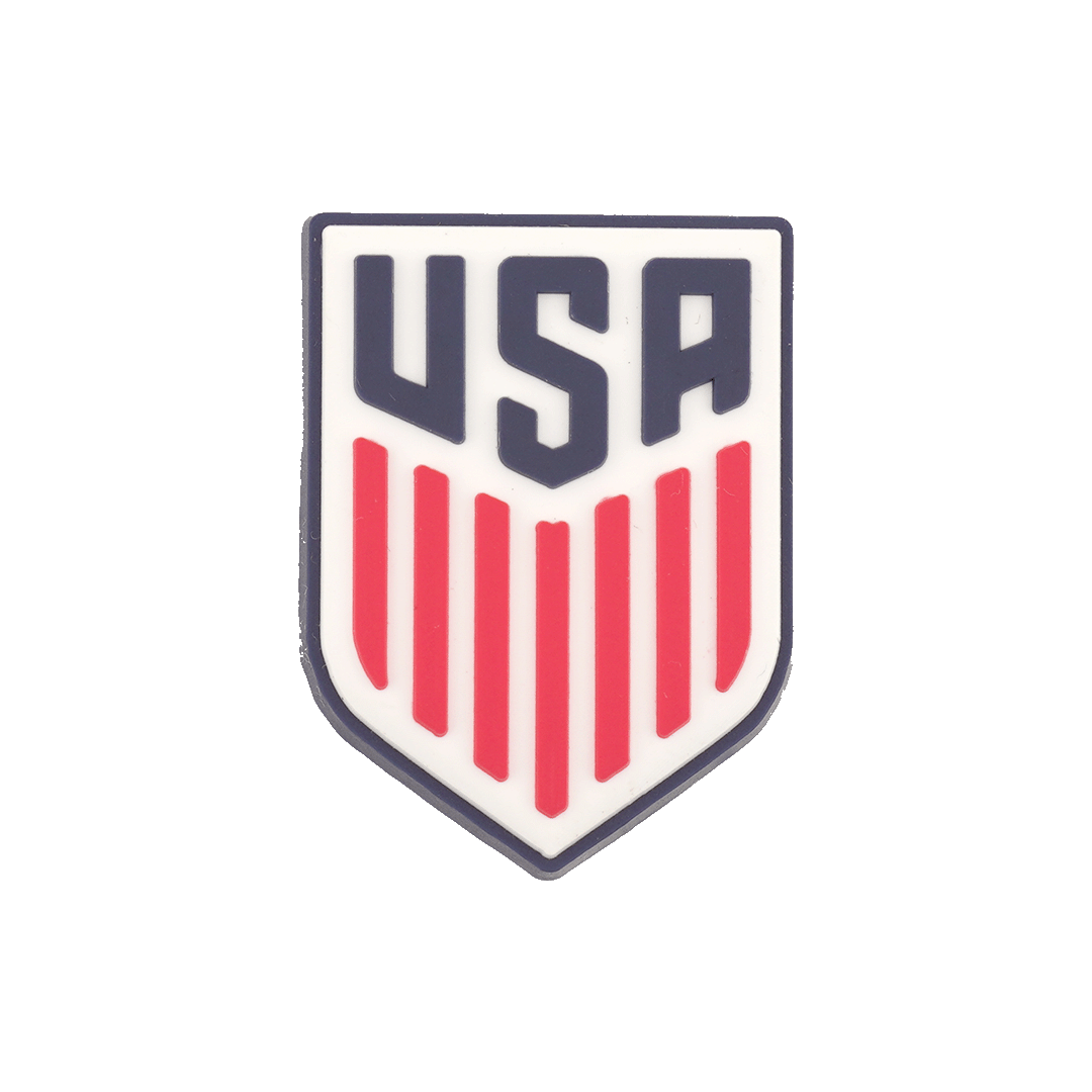 Shield-shaped crest with dark blue "USA" block lettering above seven vertical red stripes on a white background.