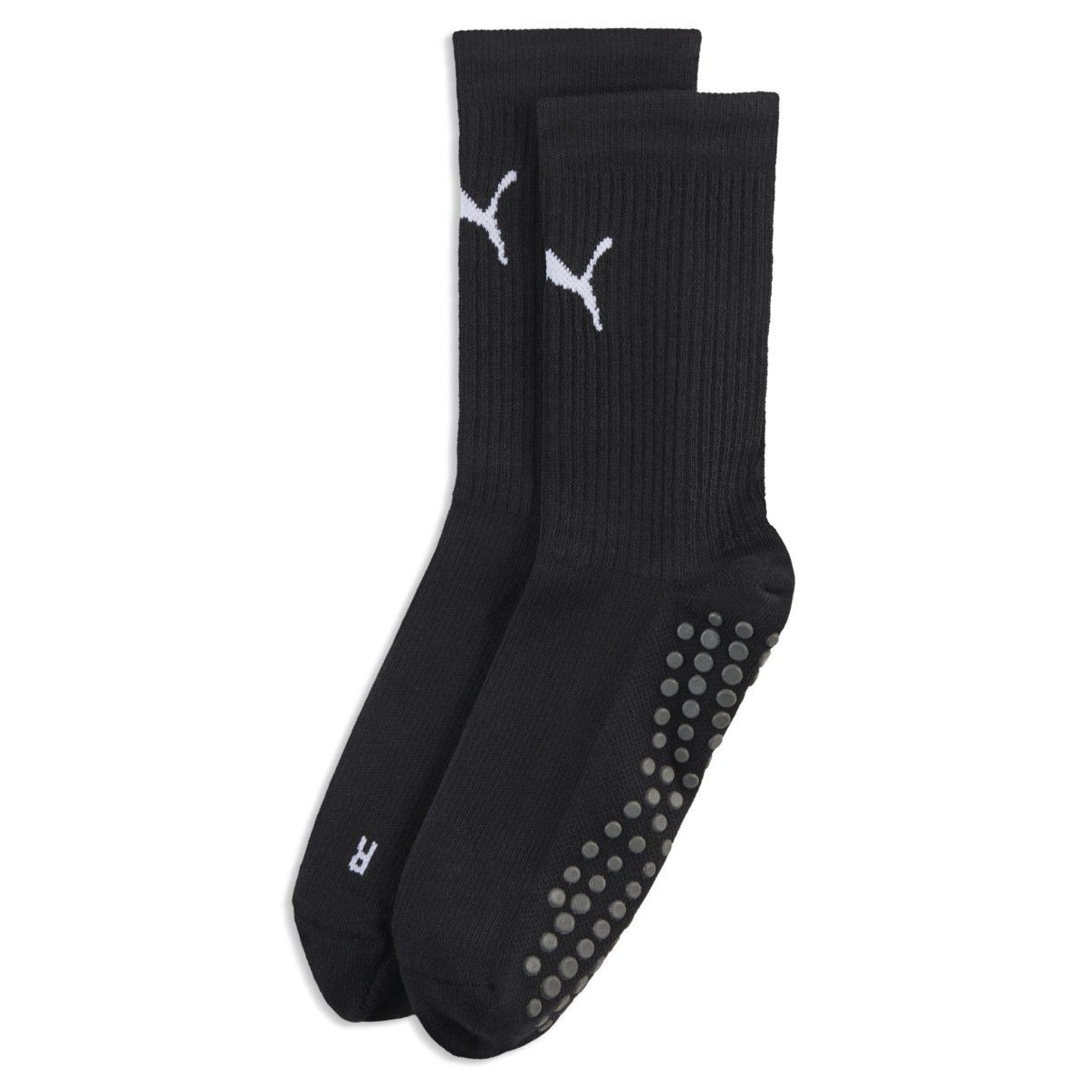 A pair of black crew socks with white Puma logos, ribbed ankles, and grey non-slip grip dots on the soles, set against a black background.
