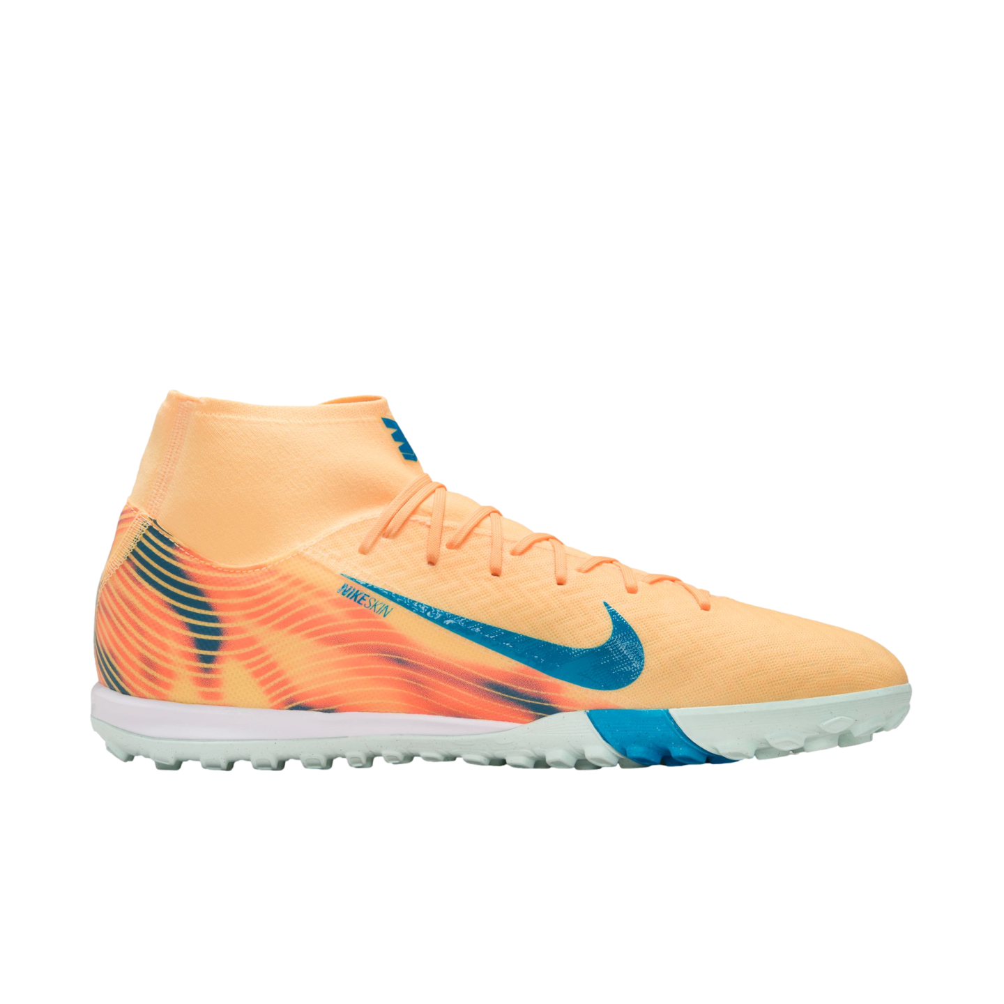 A peach-colored Nike turf soccer shoe with blue accents and a high-top collar, shown in profile against a black background.