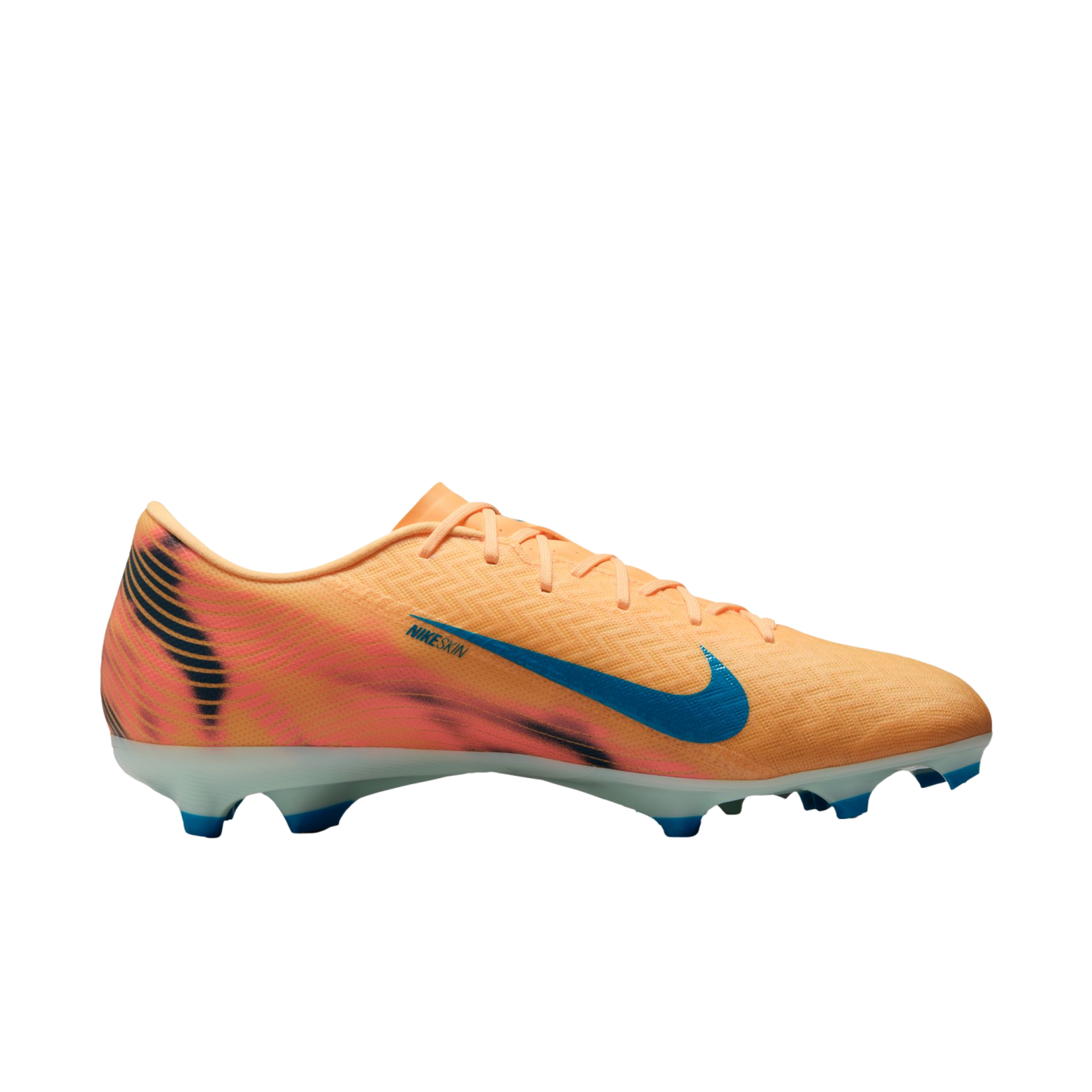 Side profile of a peach Nike soccer cleat with a blue Swoosh and tiger-stripe heel detail. It has a white sole with blue studs, set against a solid black background.